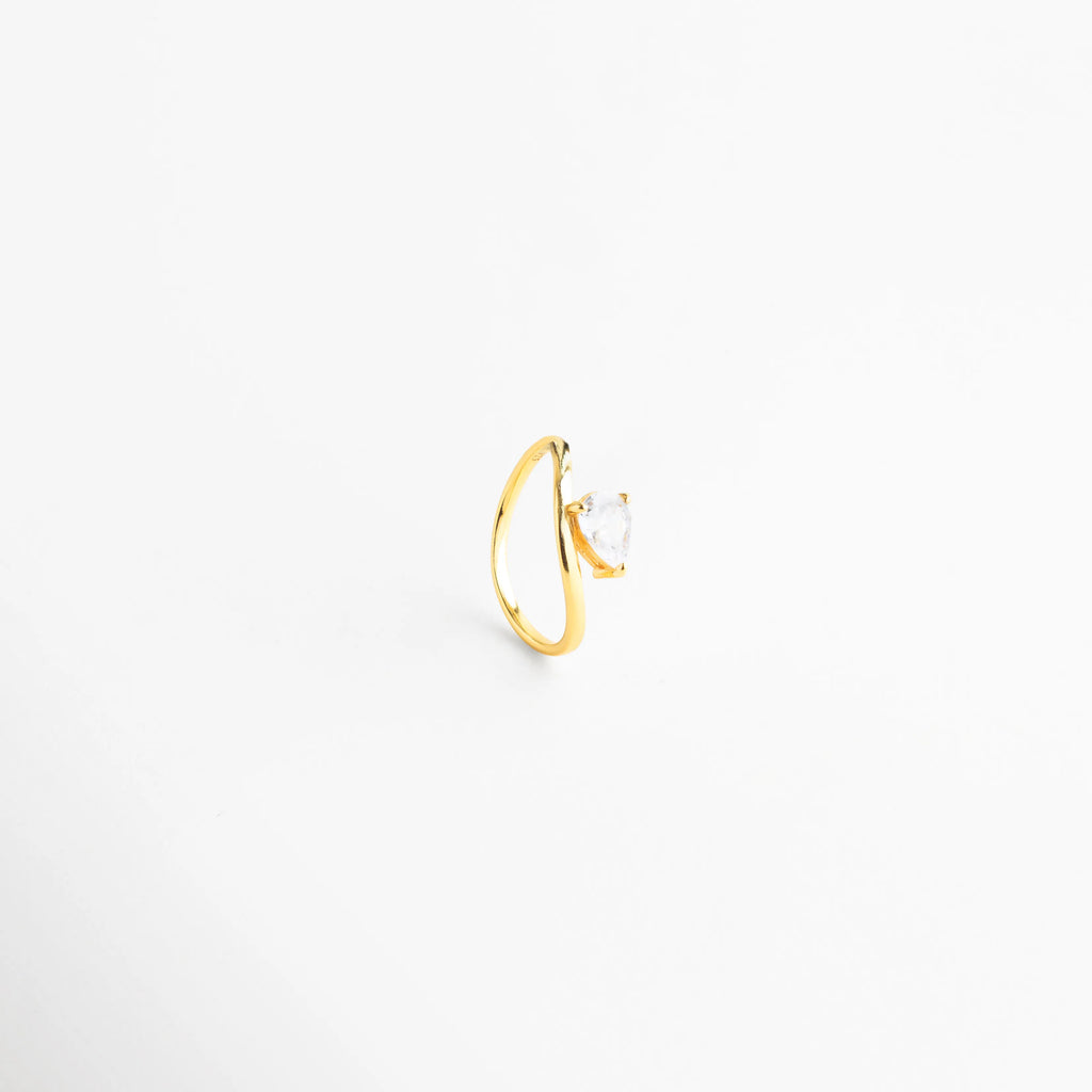 Vista desde arriba de anillo de plata 925 resaltando la forma de la zirconia, Detalle del corte de la zirconia en anillo dorado de diseño curvo, Perspectiva cenital de sortija elegante de plata con brillo superior, Anillo de banda abierta visualmente con piedra central transparente, Diseño de anillo de "gota" en plata ley 925 con acabado enchapado.