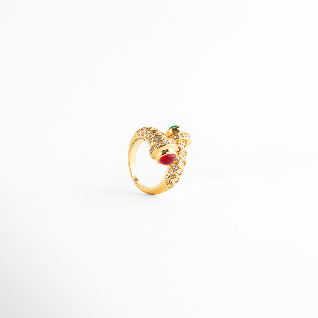 vista superior de anillo dorado con piedra roja, anillo con detalle central llamativo, joyería dorada con diseño protagonista, anillo elegante con acabado pulido, anillo con contraste de color rojo, anillo moderno de inspiración glam