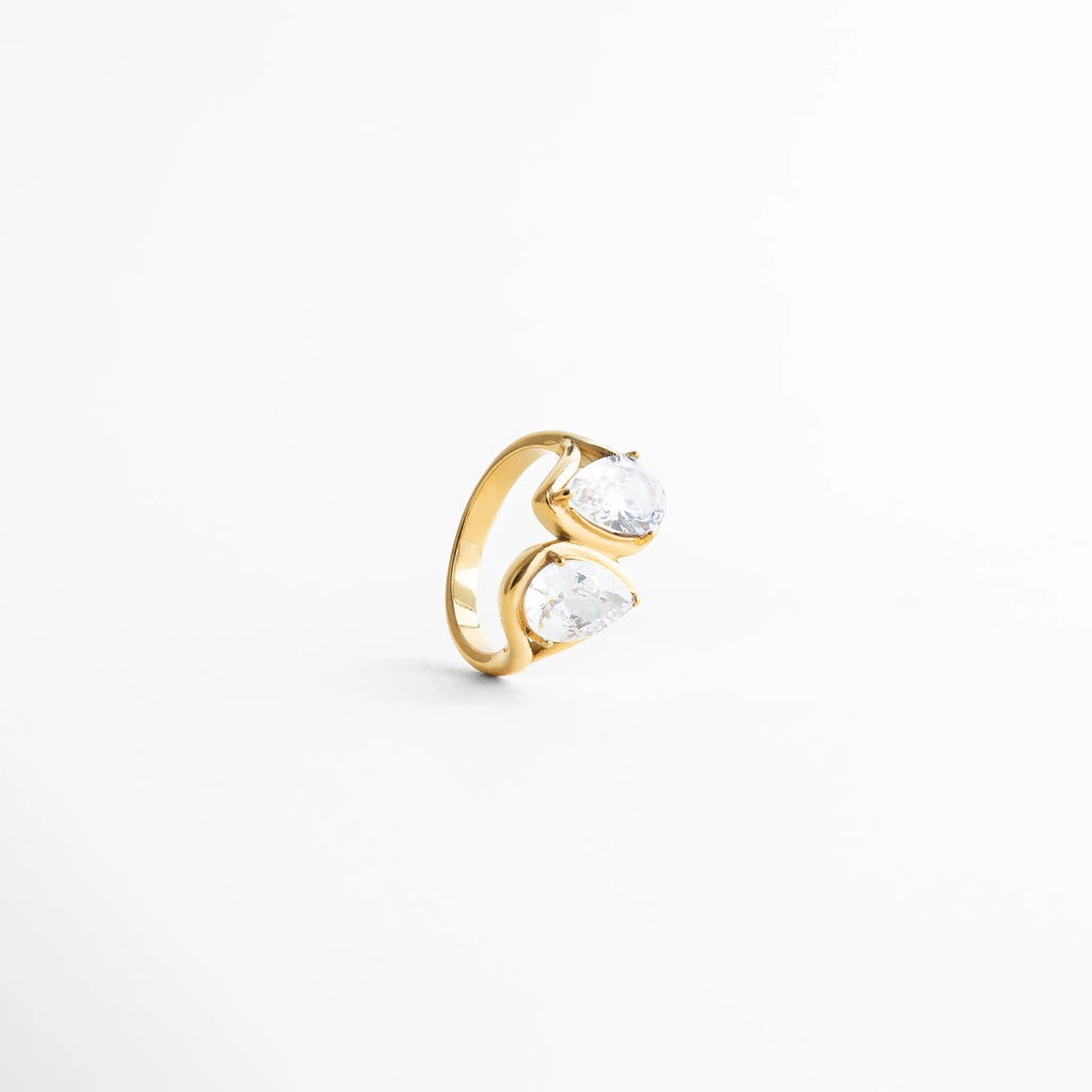 Detalle de zirconias en anillo dorado brillante, Acercamiento a piedras zirconia en anillo Blake, Detalle de incrustaciones brillantes en anillo elegante, Zirconias reflejando luz en anillo dorado, Anillo con piedras brillantes en diseño sofisticado