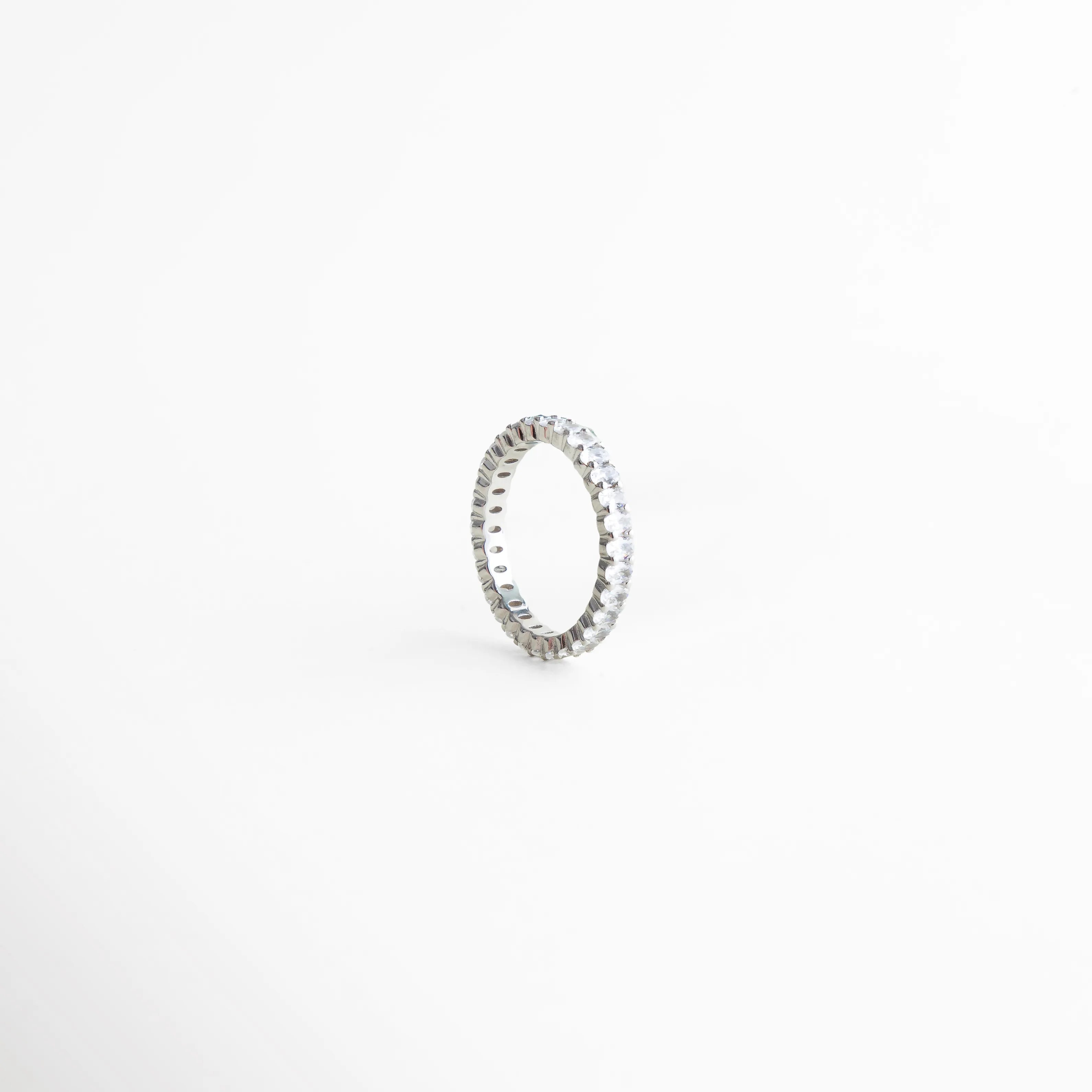 detalle de zirconias en anillo churumbela, anillo delicado con brillo sutil, joyería fina con engaste continuo, anillo minimalista de acabado pulido, anillo elegante de estética sofisticada