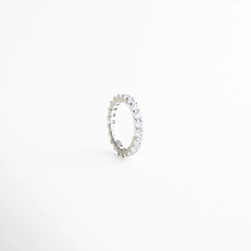 detalle de zirconias engastadas en anillo, anillo churumbela con acabado pulido, joyería fina con brillo discreto, anillo delicado de diseño continuo, anillo elegante de estética refinada, anillo minimalista con zirconias