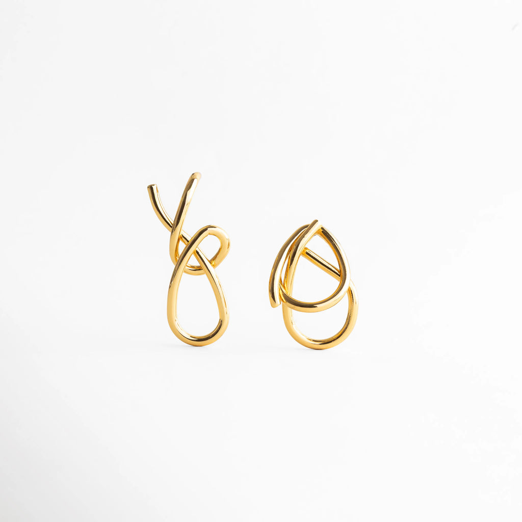 aretes dorados de diseño orgánico tipo nudo, aretes statement dorados con líneas entrelazadas, joyería dorada moderna con acabado pulido, aretes elegantes dorados de estilo escultórico, aretes femeninos dorados de diseño contemporáneo, aretes dorados minimalistas con volumen