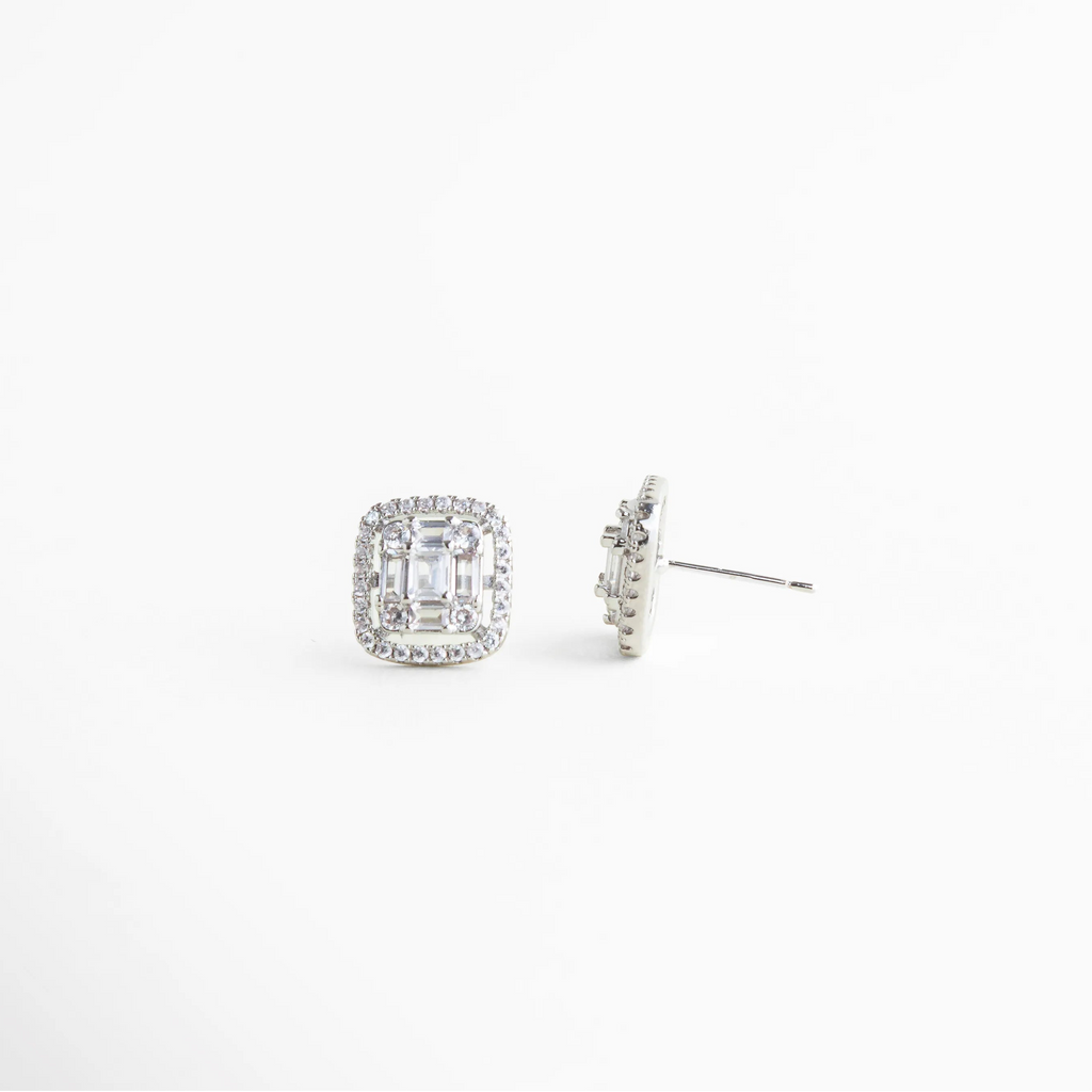 Perfil de aretes pequeños plateados tipo stud, Aretes delicados plateados con estructura ligera, Vista lateral de aretes minimalistas con cristales claros, Aretes plateados compactos y elegantes, Diseño discreto de aretes plateados para uso diario