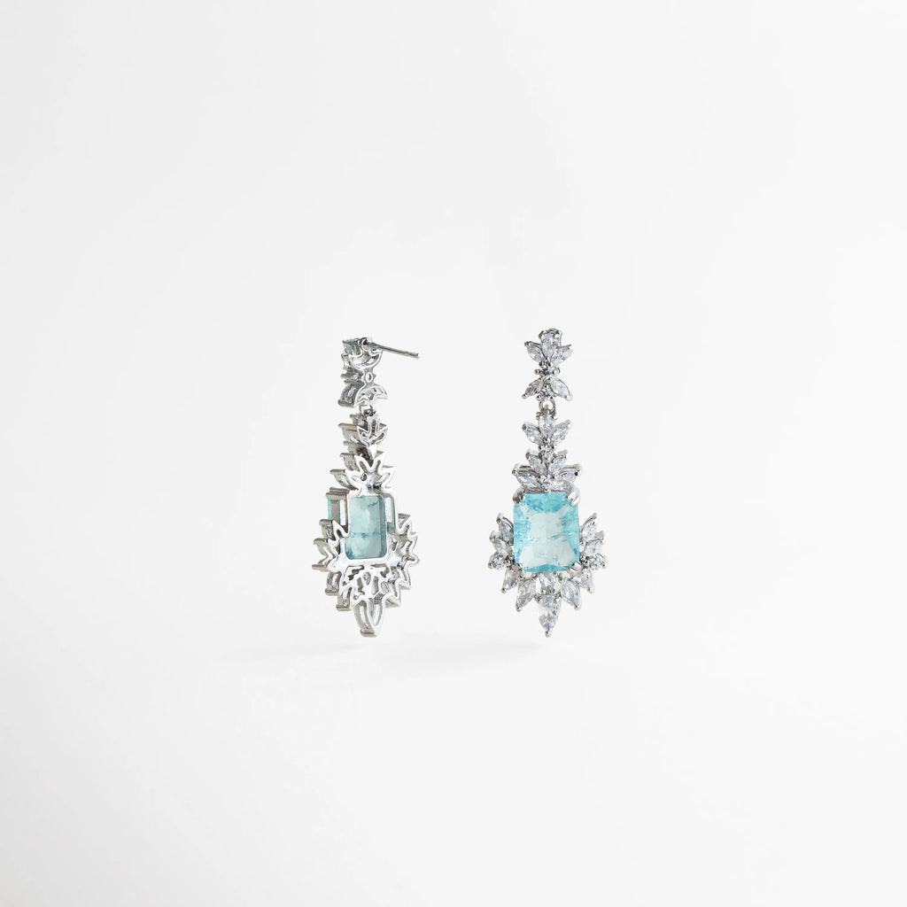 aretes con cristales brillantes, joyería con piedra azul clara, aretes plateados sofisticados, accesorios elegantes mujer, aretes de ocasión especial, joyería luminosa moderna, aretes románticos, aretes statement elegantes