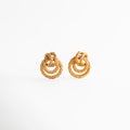 aretes dorados con diseño entrelazado de forma orgánica, aretes statement pequeños con acabado texturizado, joyería elegante con curvas entrelazadas y brillo sutil, aretes tipo nudo dorado de estilo sofisticado, aretes modernos con volumen y detalle artesanal