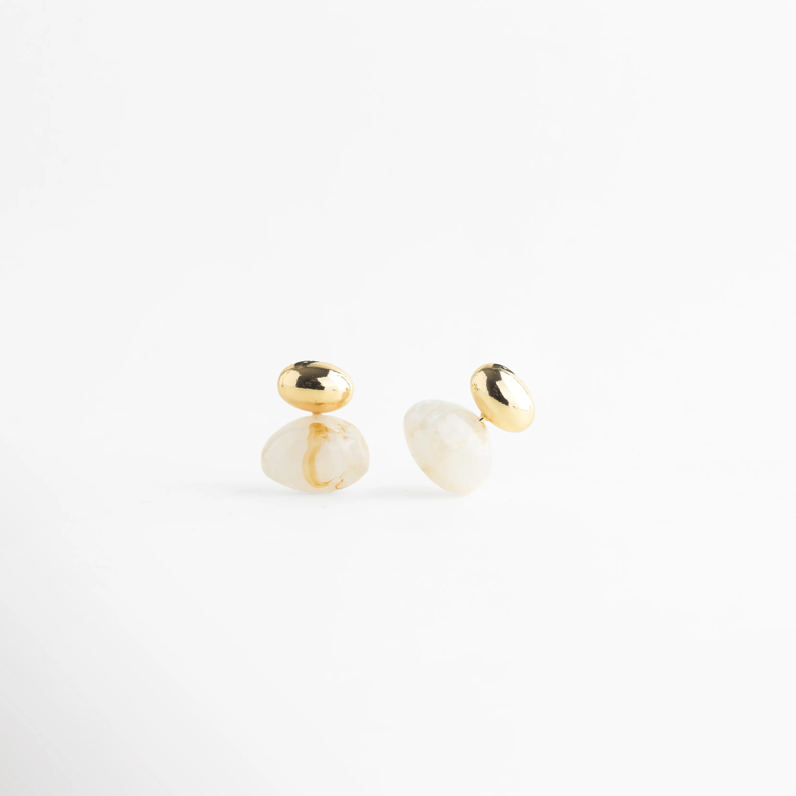 aretes con piedra blanca vista lateral joyería fina Monterrey, aretes orgánicos con piedra blanca detalle metálico, aretes modernos con piedra blanca vista angular, aretes de diseño escultórico con piedra blanca, aretes dorados con piedra blanca vista 3/4