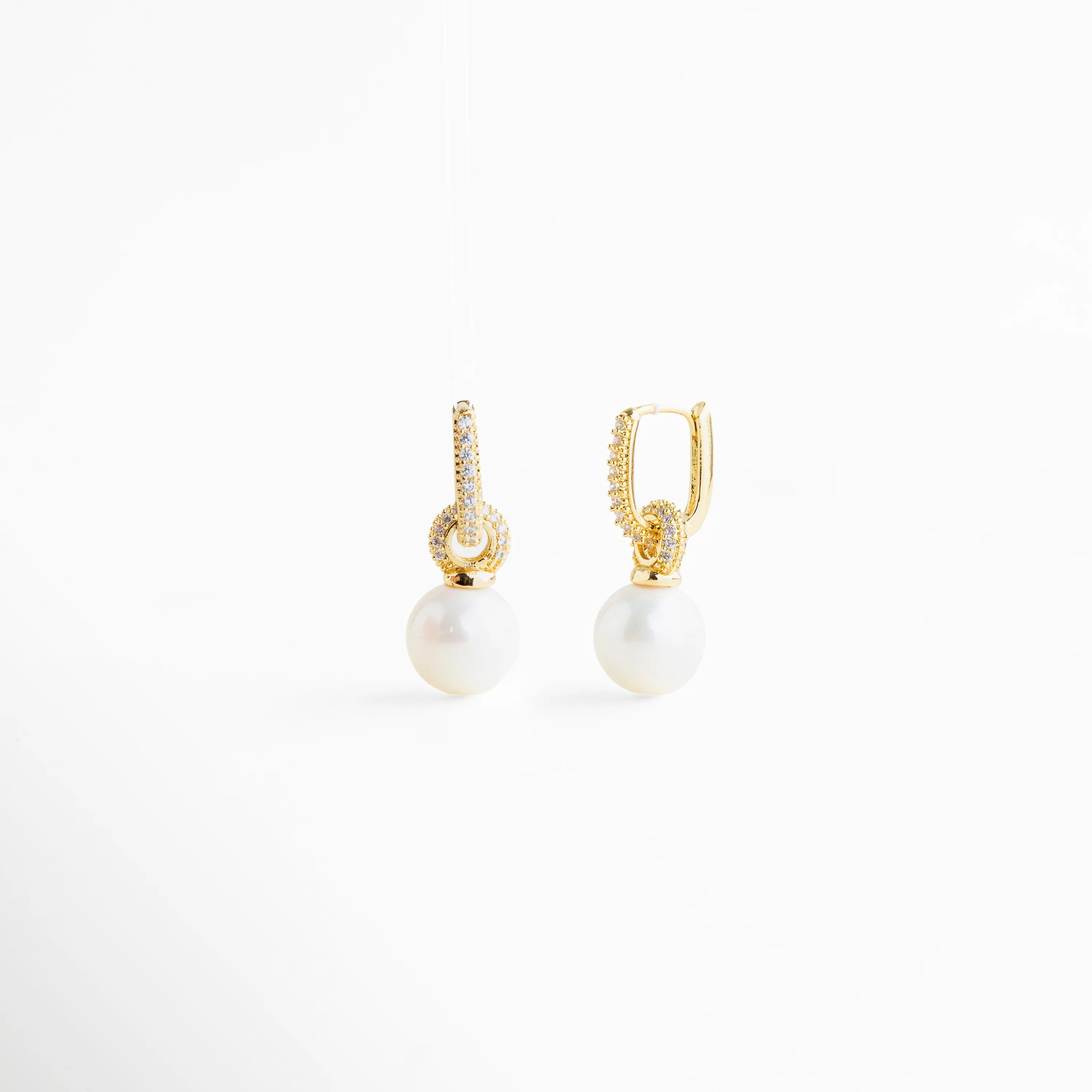 aretes dorados con perla colgante y zirconias, aretes elegantes con perla blanca y detalle brillante, aretes finos con perla y aro dorado, aretes con perla colgante estilo europeo, joyería fina aretes con perla Monterrey