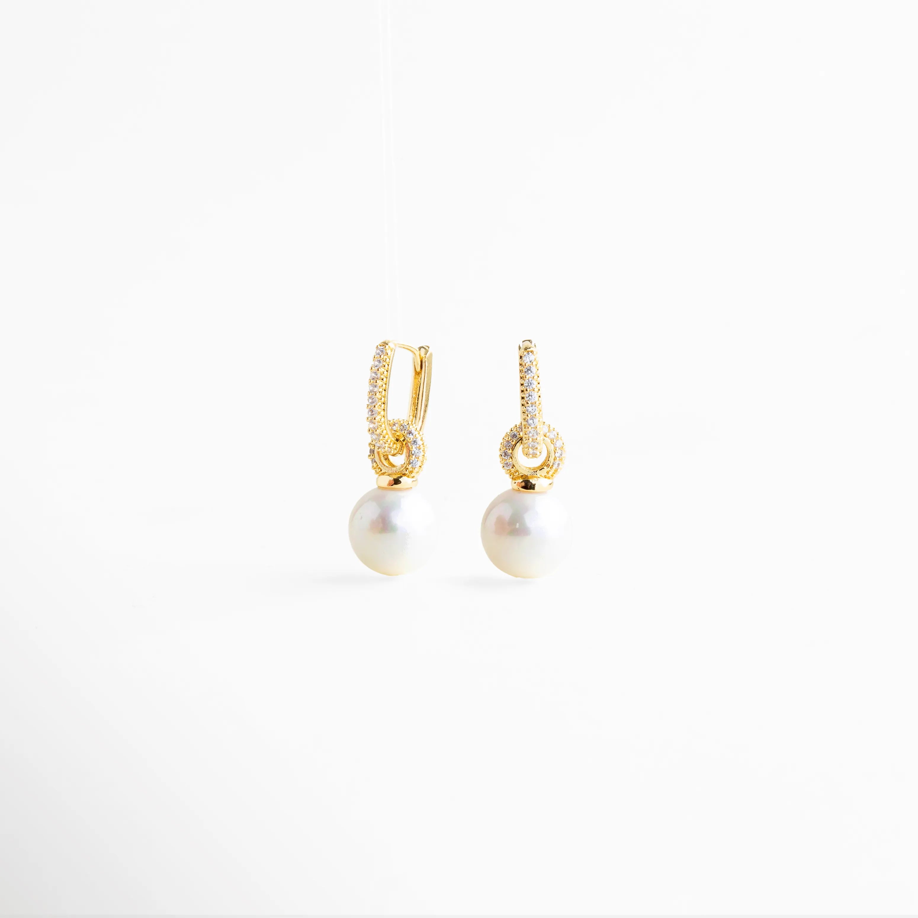 aretes con perla vista lateral y zirconias, aretes dorados con perla colgante perfil, aretes elegantes con perla lateral, aretes minimalistas con perla y brillo, aretes de joyería fina San Pedro Garza García
