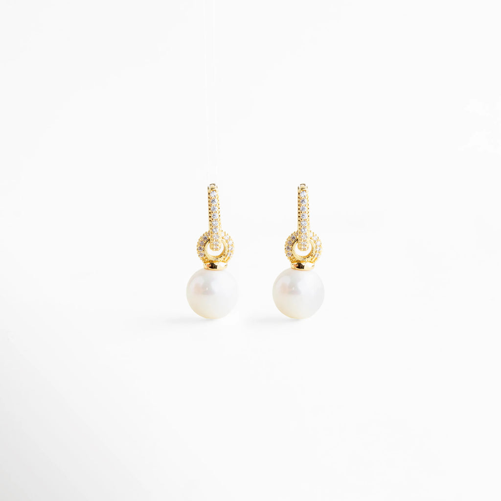 detalle de zirconias en aretes con perla, perla lisa colgante en aretes elegantes, acabado dorado en aretes con perla, textura y brillo de aretes con perla, detalle fino de joyería aretes Monterrey