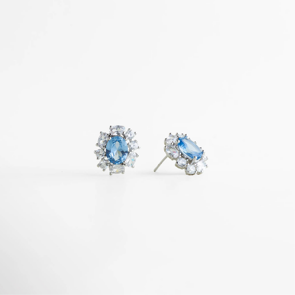 Aretes stud plateados con poste y broche de presión, Cierre de aretes plateados tipo stud, Detalle lateral de aretes con piedra azul, Aretes cómodos y ligeros con broche seguro, Vista trasera de aretes plateados elegantes, Aretes pequeños con estructura fina y pulida