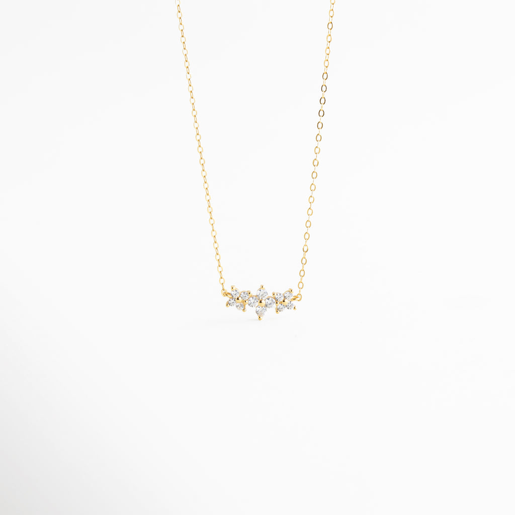 Collar de Plata 925 con baño de oro 18K y dije de flores con circonias brillantes, Gargantilla dorada fina con colgante de cristales en forma de racimo floral, Vista frontal de collar minimalista en oro con incrustaciones de circonia transparente, Joyería de plata ley 925: collar con dije de 1.5 cm decorado con piedras brillantes, Collar elegante con cadena delgada y motivo floral de circonias para mujer.