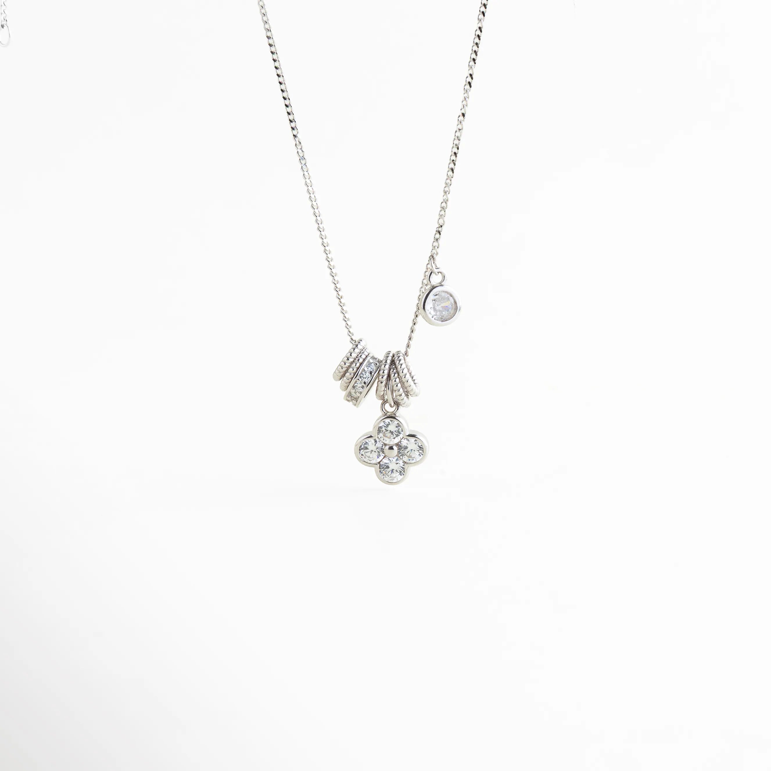Vista completa de collar de Plata Ley 925 con caída de dijes en cascada, Collar elegante de plata con dije de trébol y elementos circulares brillantes, Composición vertical de gargantilla de plata con zirconias para mujer, Collar de diseño contemporáneo con múltiples dijes de plata y brillo cristalino, Joya de plata ley 925 minimalista con colgantes móviles de zirconias.