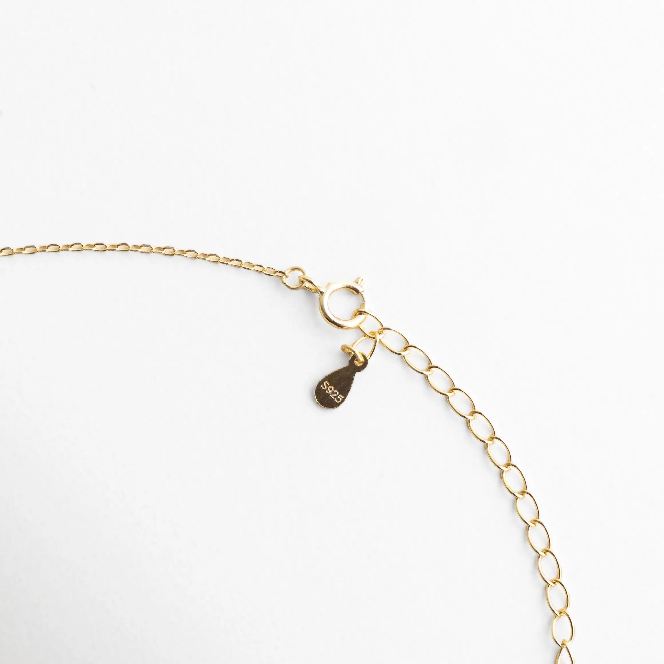 Cierre ajustable dorado con extensión y charm en forma de gota, ideal para un ajuste cómodo y un toque delicado.