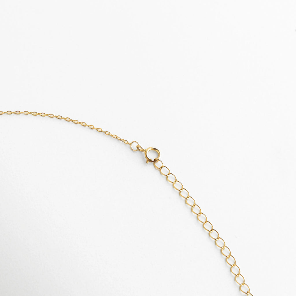 Detalle del broche de reasa de seguridad en collar de Plata 925 con acabado en oro, Vista técnica de la cadena de extensión para ajustar el largo del collar punto de luz, Primer plano del cierre ajustable de joyería fina, resaltando el pulido del baño de oro, Sistema de cierre seguro y eslabones de ajuste para gargantilla minimalista de zirconia, Reverso del collar de plata dorada mostrando la calidad del herraje y la placa de autenticidad.