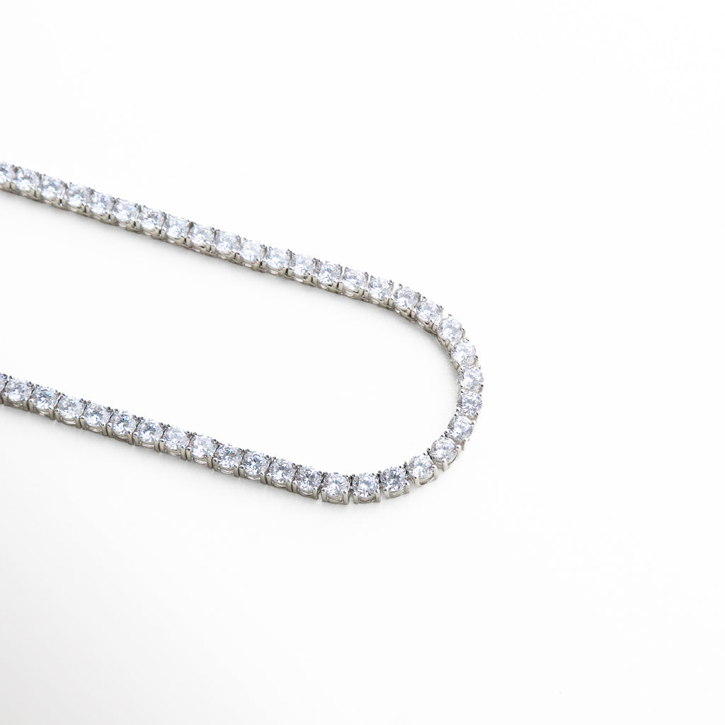 detalle de zirconias brillantes en collar tennis plateado
piedras engastadas en línea en collar estilo tennis
acabado brillante en collar de zirconias plateado elegante
detalle de cristales alineados en collar plateado fino
textura de piedras tipo diamante en collar tennis plateado