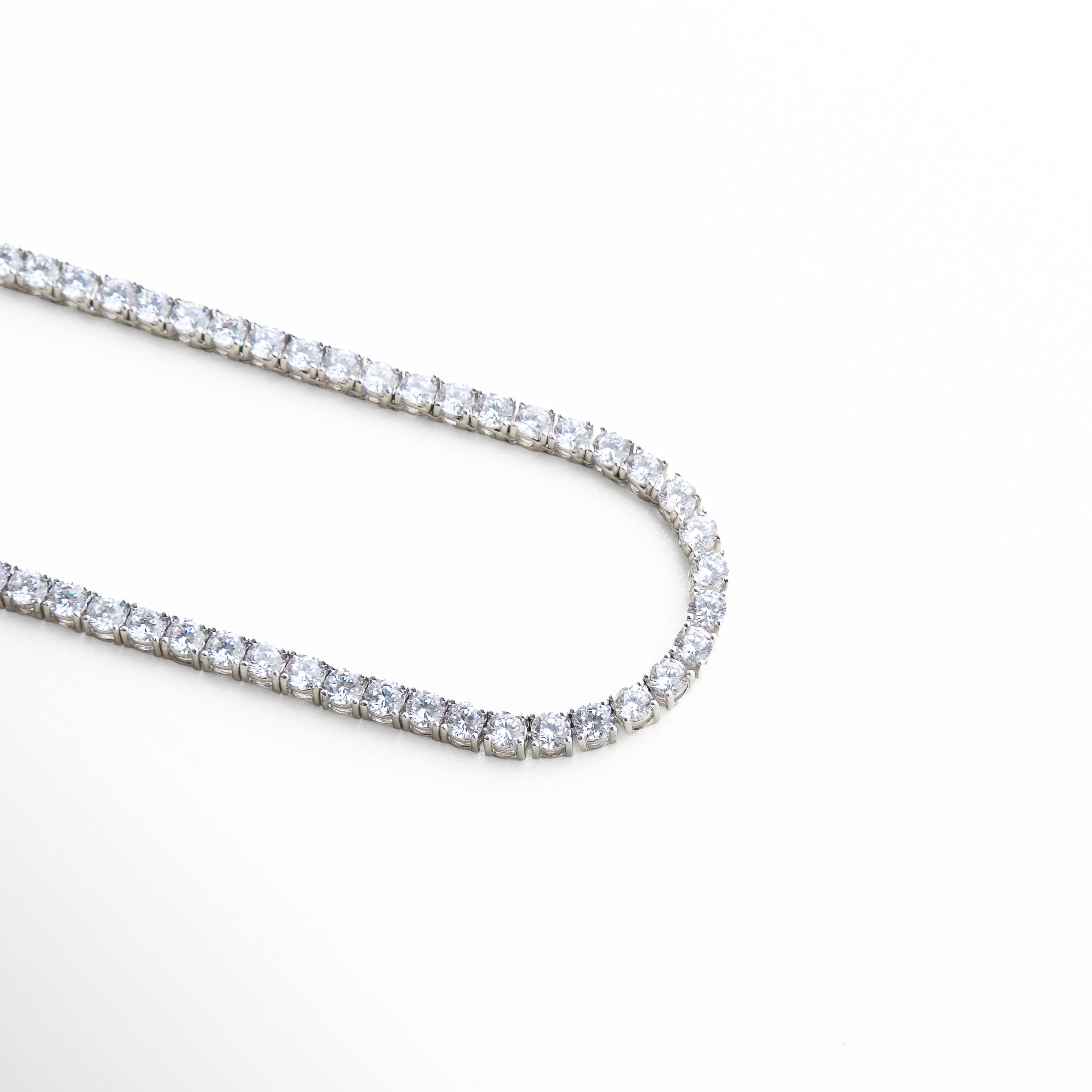 detalle de zirconias brillantes en collar tennis plateado
piedras engastadas en línea en collar estilo tennis
acabado brillante en collar de zirconias plateado elegante
detalle de cristales alineados en collar plateado fino
textura de piedras tipo diamante en collar tennis plateado