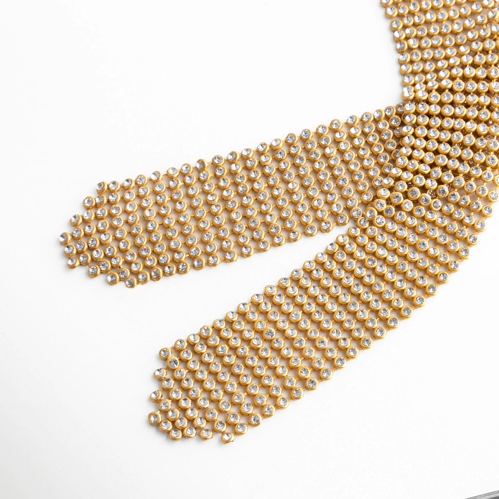 detalle de malla dorada flexible en collar statement
textura de cadena tipo mesh dorada elegante
acabado de malla fina dorada en collar tipo corbatín
diseño de eslabones pequeños en collar dorado ancho
detalle textil metálico en collar dorado moderno