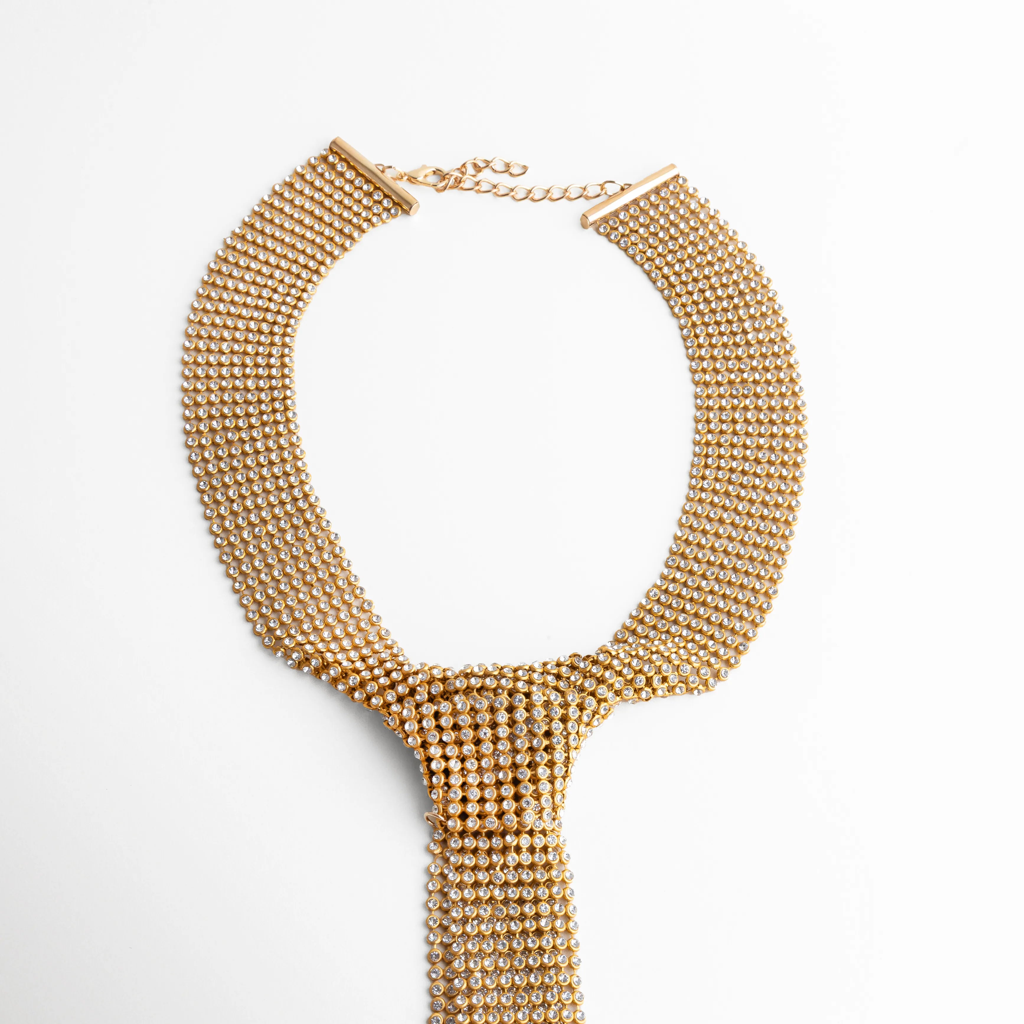 collar dorado tipo corbatín colocado en cuello
diseño de collar statement con caída frontal elegante
collar tipo corbata dorado estilo sofisticado
pieza protagonista dorada para outfit elegante
collar de impacto dorado con diseño moderno