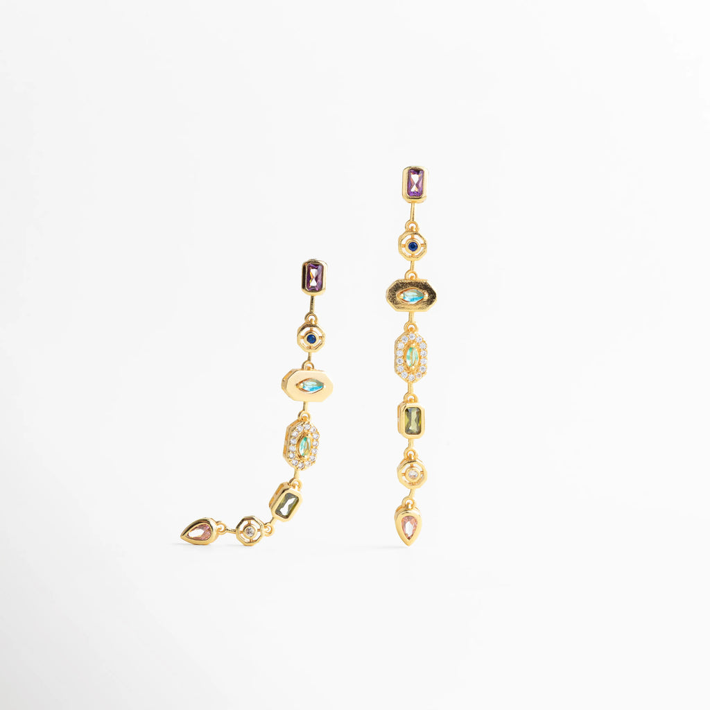 Aretes dorados largos vistos de perfil con movimiento fluido, Detalle lateral de aretes dorados con piedras engastadas, Aretes colgantes dorados con acabado pulido y elegante, Diseño lateral de aretes largos dorados modernos, Aretes dorados sofisticados con caída vertical estilizada