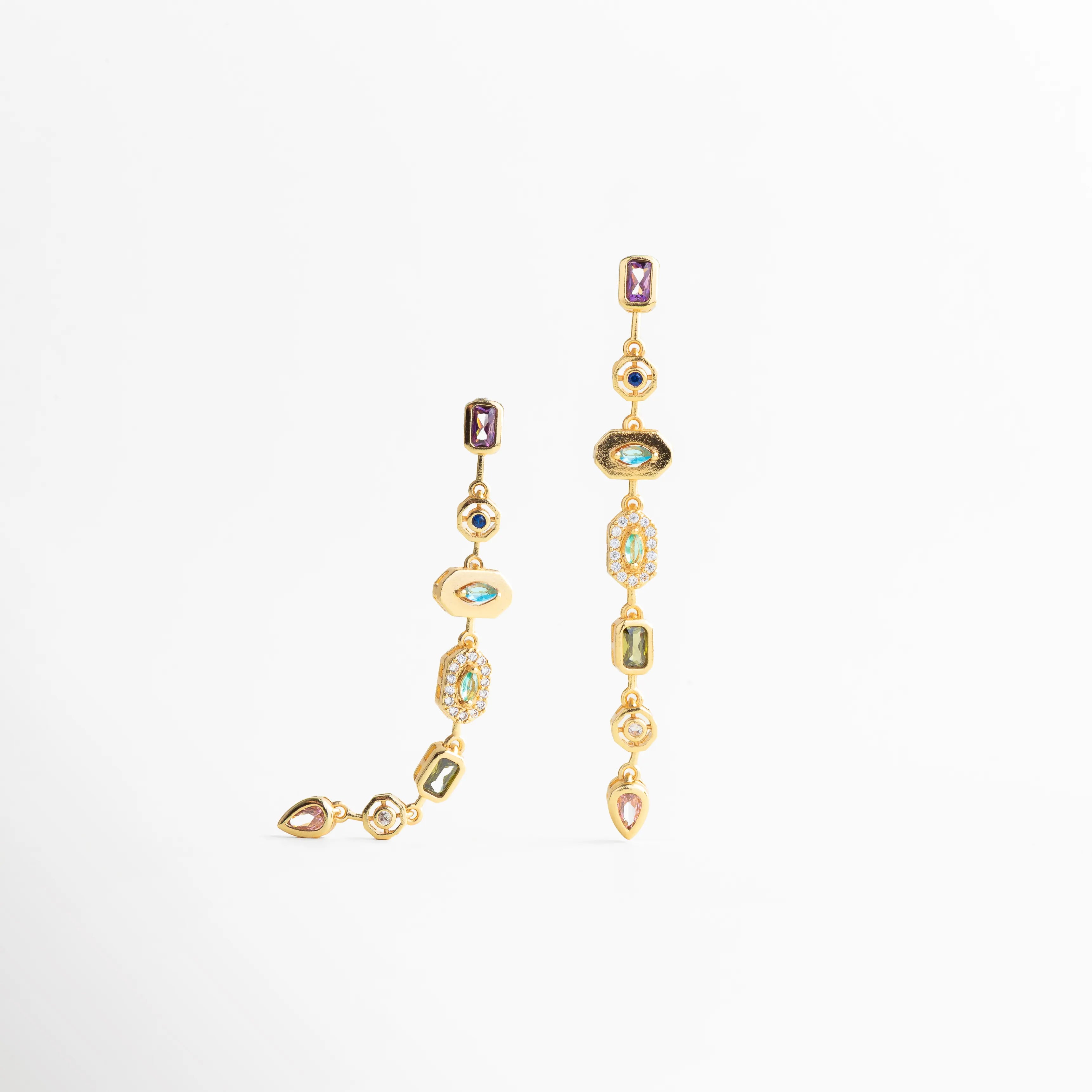 Aretes dorados largos vistos de perfil con movimiento fluido, Detalle lateral de aretes dorados con piedras engastadas, Aretes colgantes dorados con acabado pulido y elegante, Diseño lateral de aretes largos dorados modernos, Aretes dorados sofisticados con caída vertical estilizada
