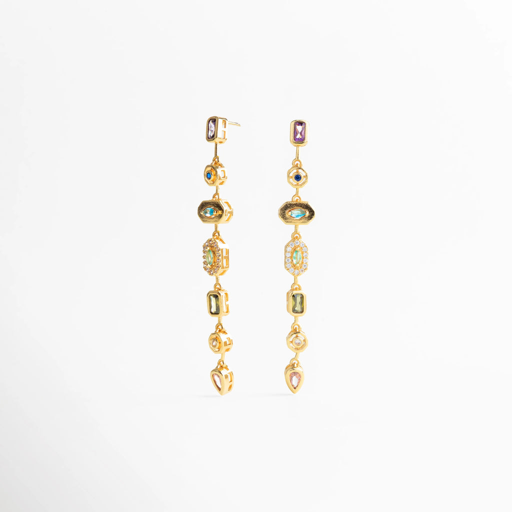 Detalle de piedras engastadas en aretes largos dorados, Textura y brillo de aretes dorados con diseño refinado, Acabado pulido en aretes dorados de estilo statement, Detalle cercano de joyería dorada con piedras decorativas, Aretes largos dorados con trabajo fino en cada pieza