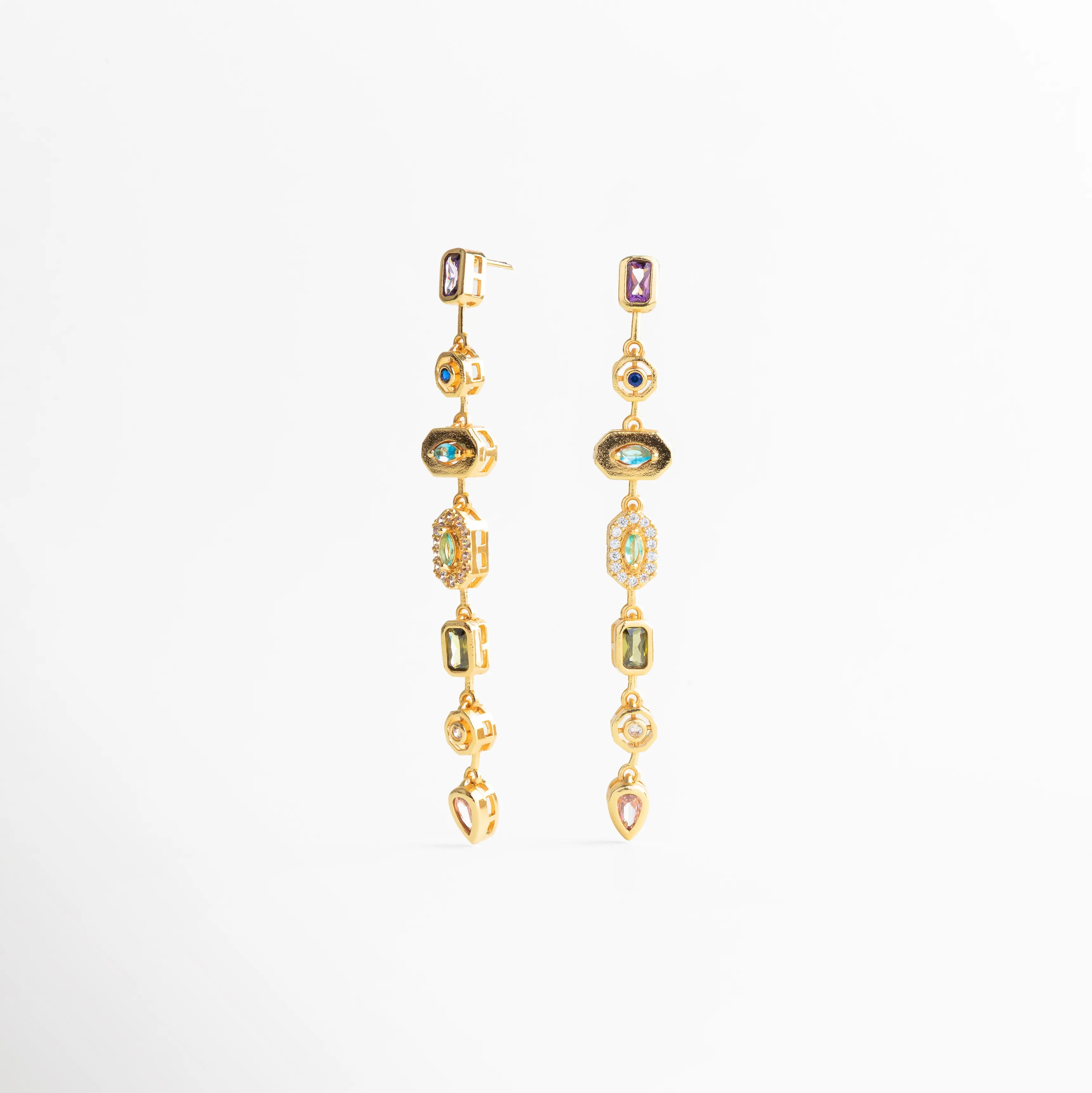 Detalle de piedras engastadas en aretes largos dorados, Textura y brillo de aretes dorados con diseño refinado, Acabado pulido en aretes dorados de estilo statement, Detalle cercano de joyería dorada con piedras decorativas, Aretes largos dorados con trabajo fino en cada pieza