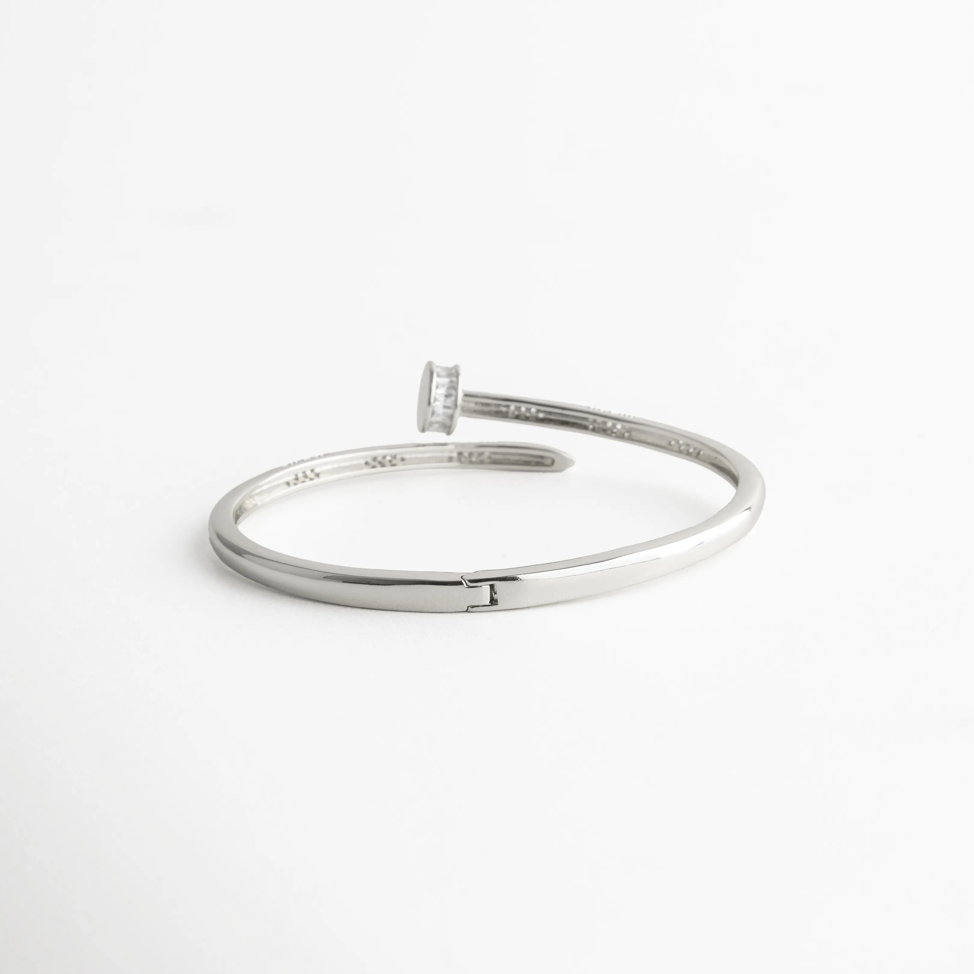 pulsera clavo plateada abierta vista lateral, brazalete plateado elegante con circonias, joyería moderna fina