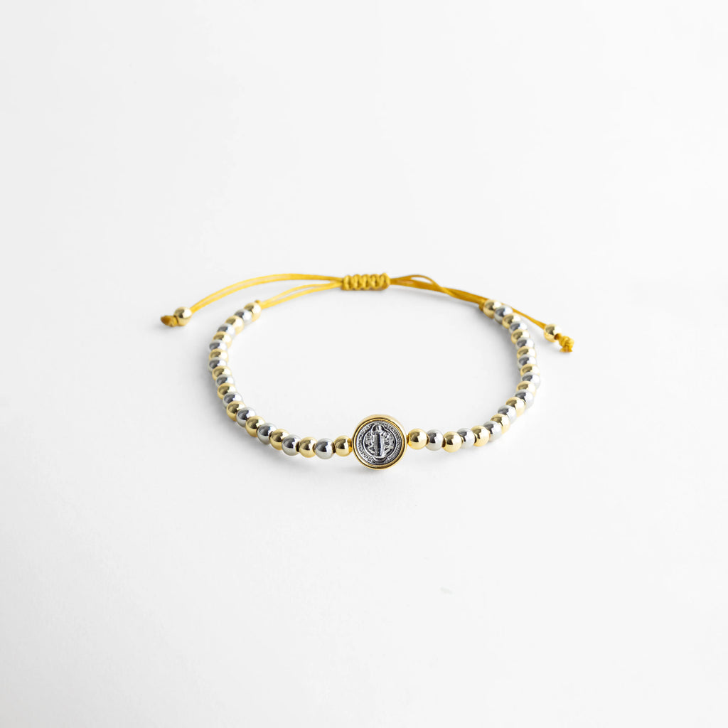 Pulsera ajustable con hilo y cuentas en oro y oro blanco 18K, diseño elegante, Pulsera artesanal de cobre con recubrimiento en oro 18K y detalle central, Pulsera fina con hilo ajustable y cuentas metálicas en acabado dorado, Pulsera elegante con combinación de oro y oro blanco, estilo minimalista, Pulsera ajustable para mujer con diseño delicado y acabado brillante