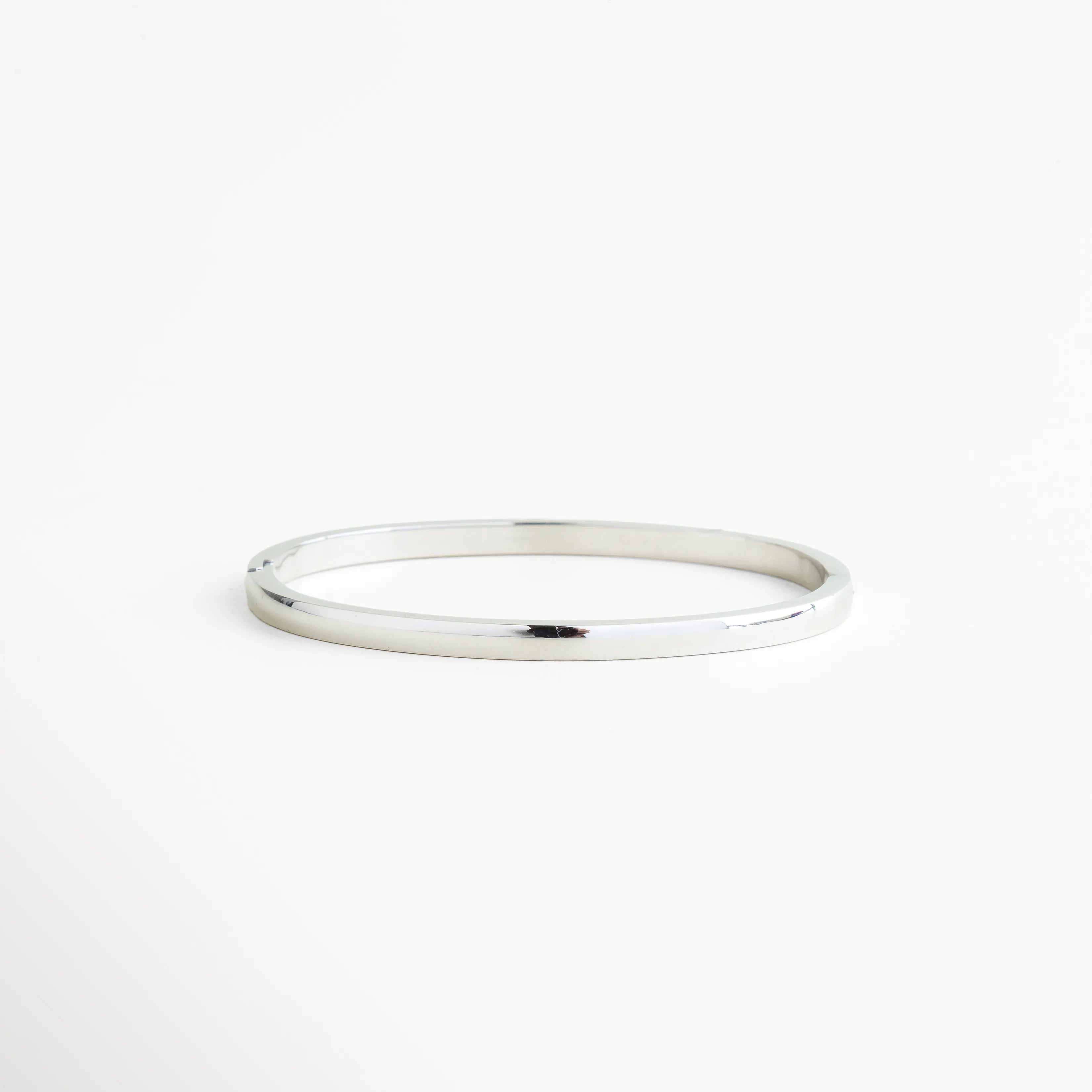 pulsera plateada vista superior con zirconias, pulsera rígida con incrustaciones brillantes, pulsera de lujo plateada diseño uniforme, pulsera delgada con zirconias alineadas, pulsera elegante vista plana, pulsera tipo tennis rígida plateada