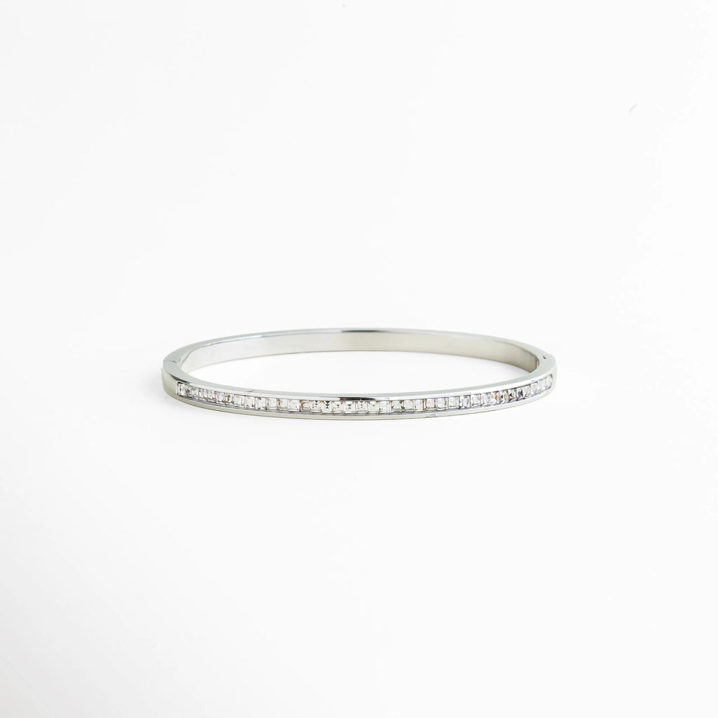 pulsera rígida plateada con zirconias engastadas, pulsera tipo bangle delgada con brillo continuo, pulsera elegante plateada con fila de zirconias, pulsera minimal plateada joyería fina, pulsera de zirconias corte baguette, pulsera femenina plateada diseño limpio