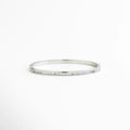 pulsera rígida plateada con zirconias engastadas, pulsera tipo bangle delgada con brillo continuo, pulsera elegante plateada con fila de zirconias, pulsera minimal plateada joyería fina, pulsera de zirconias corte baguette, pulsera femenina plateada diseño limpio