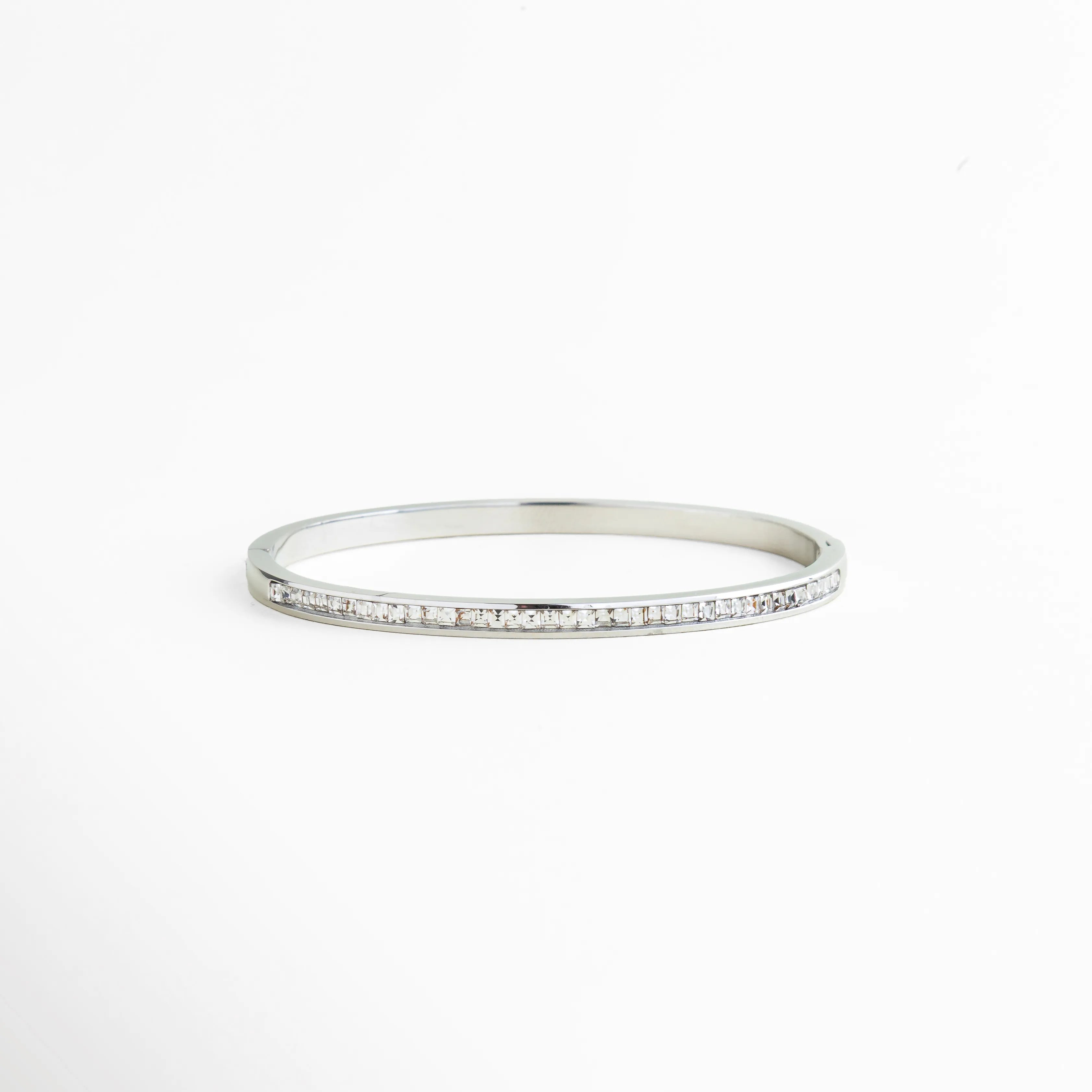 pulsera rígida plateada con zirconias engastadas, pulsera tipo bangle delgada con brillo continuo, pulsera elegante plateada con fila de zirconias, pulsera minimal plateada joyería fina, pulsera de zirconias corte baguette, pulsera femenina plateada diseño limpio