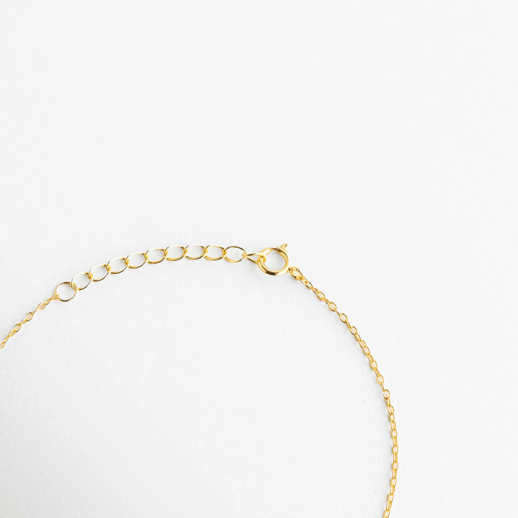 Vista del broche de reasa y cadena de extensión de 3 cm en pulsera de plata 925, Detalle técnico del sistema de ajuste y eslabones finales de pulsera dorada, Cierre seguro de joyería fina en plata de ley con baño de oro, Extensión de cadena para pulsera ajustable, permitiendo largo de 17 a 20 cm, Calidad del acabado dorado en el broche y cadena ajustable de la pulsera.