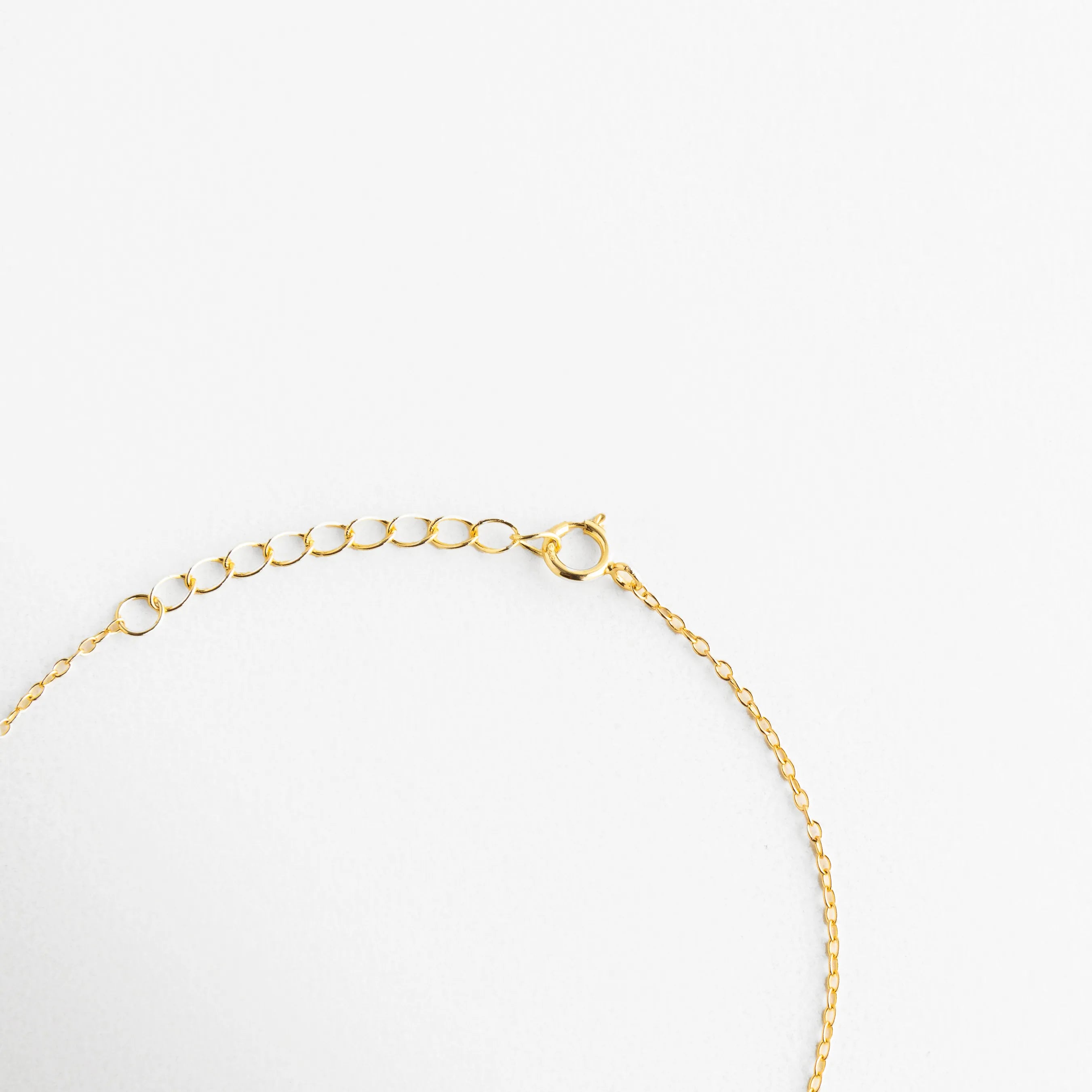 Vista del broche de reasa y cadena de extensión de 3 cm en pulsera de plata 925, Detalle técnico del sistema de ajuste y eslabones finales de pulsera dorada, Cierre seguro de joyería fina en plata de ley con baño de oro, Extensión de cadena para pulsera ajustable, permitiendo largo de 17 a 20 cm, Calidad del acabado dorado en el broche y cadena ajustable de la pulsera.