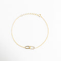 Vista aérea de pulsera de eslabones entrelazados con circonias y cadena dorada, Pulsera de diseño "Interlocking" en plata 925 con destellos de micro-circonias, Joyería minimalista: pulsera de cadena fina con detalle central asimétrico brillante, Brazalete dorado con dije de unión simbólica, ideal para regalo de aniversario o amistad, Perspectiva superior de pulsera de plata dorada resaltando la finura de la cadena.