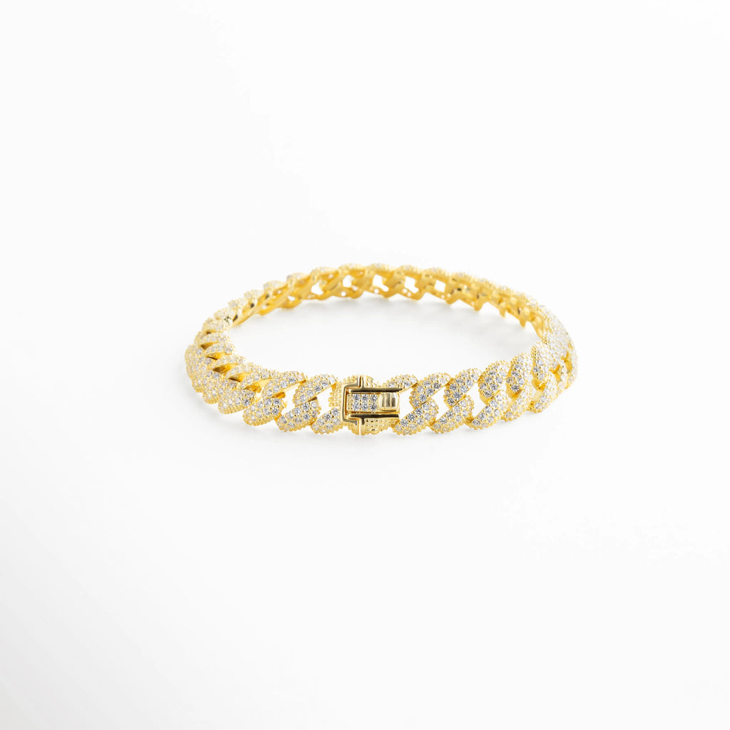 Pulsera de eslabón cubano en Plata Ley 925 con baño de oro 18k y diamantes sintéticos, Brazalete estilo "Cuban Link" dorado de 0.9 cm con pavé completo de piedras brillantes, Joyería de plata 925 dorada con incrustaciones de diamantes sintéticos y cierre de seguridad, Pulsera de eslabones planos bañada en oro de 18k con acabado "Iced Out" sobre fondo blanco, Brazalete de cadena gruesa de 16 cm en oro 18k con pedrería fina y brillo intenso.