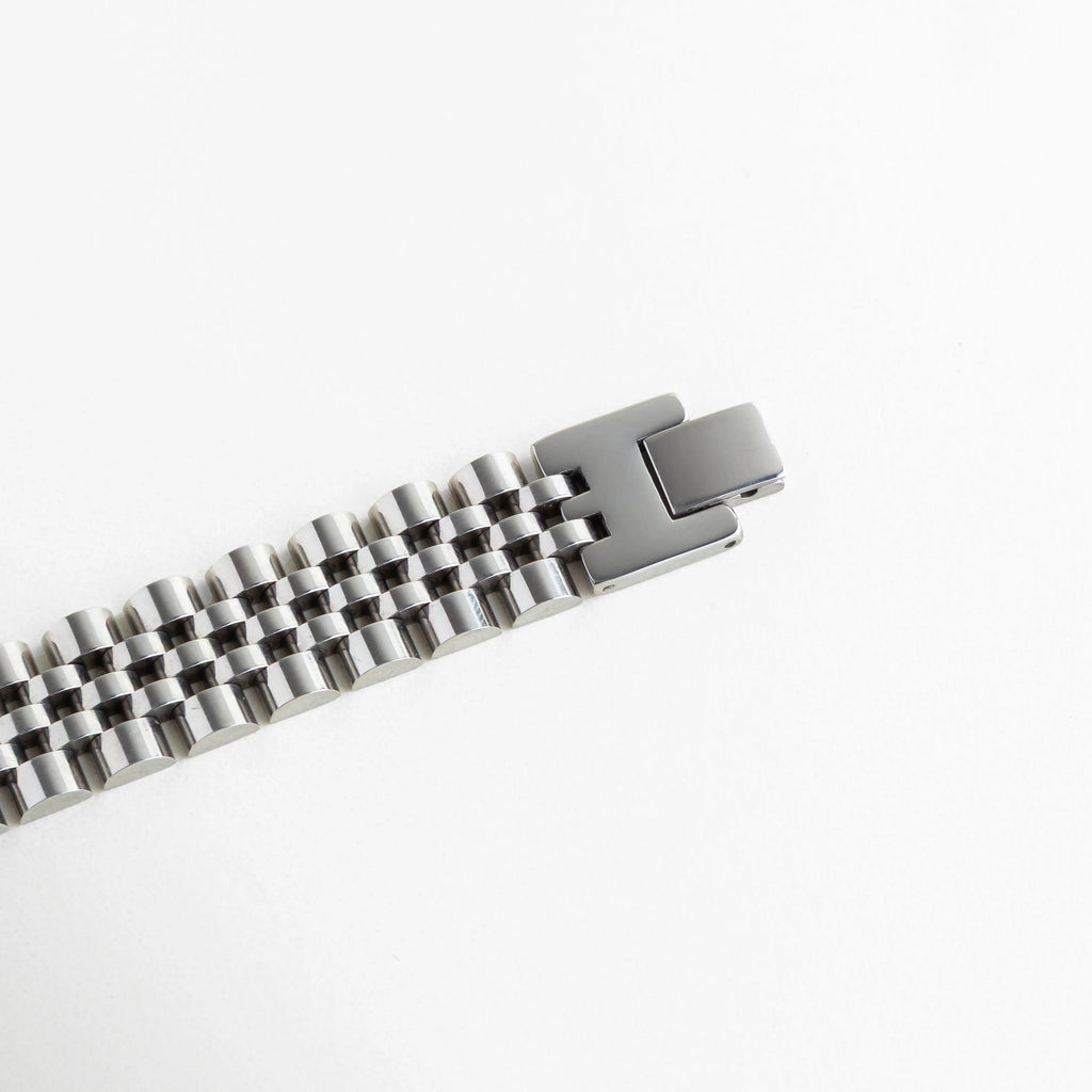Mecanismo de cierre de presión abierto en pulsera de eslabones tipo reloj, Detalle técnico del broche de seguridad para brazalete de acero enchapado, Vista del sistema de apertura y cierre fácil para pulsera plateada de 1.5 cm, Interior del broche de la pulsera resaltando la durabilidad del mecanismo, Broche desplegable abierto mostrando la longitud total de 16 cm del accesorio.