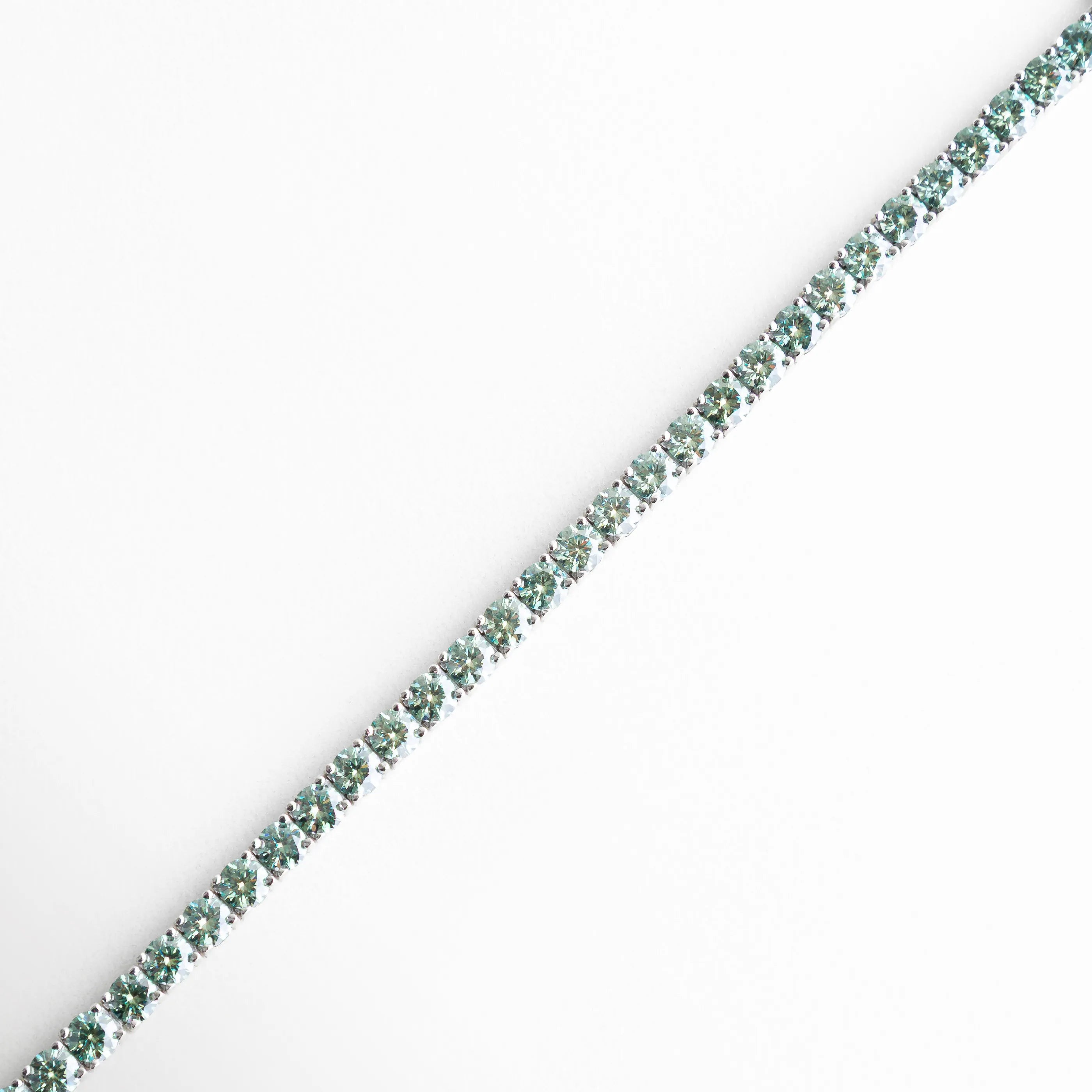 Pulsera tipo tenis extendida con moissanita verde y plata ley 925, Vista completa de pulsera fina con diamantes moissanita engastados, Pulsera alargada con piedras moissanita brillantes y acabado pulido, Diseño lineal de pulsera elegante con moissanita en plata 925, Pulsera delgada con incrustaciones verdes de moissanita