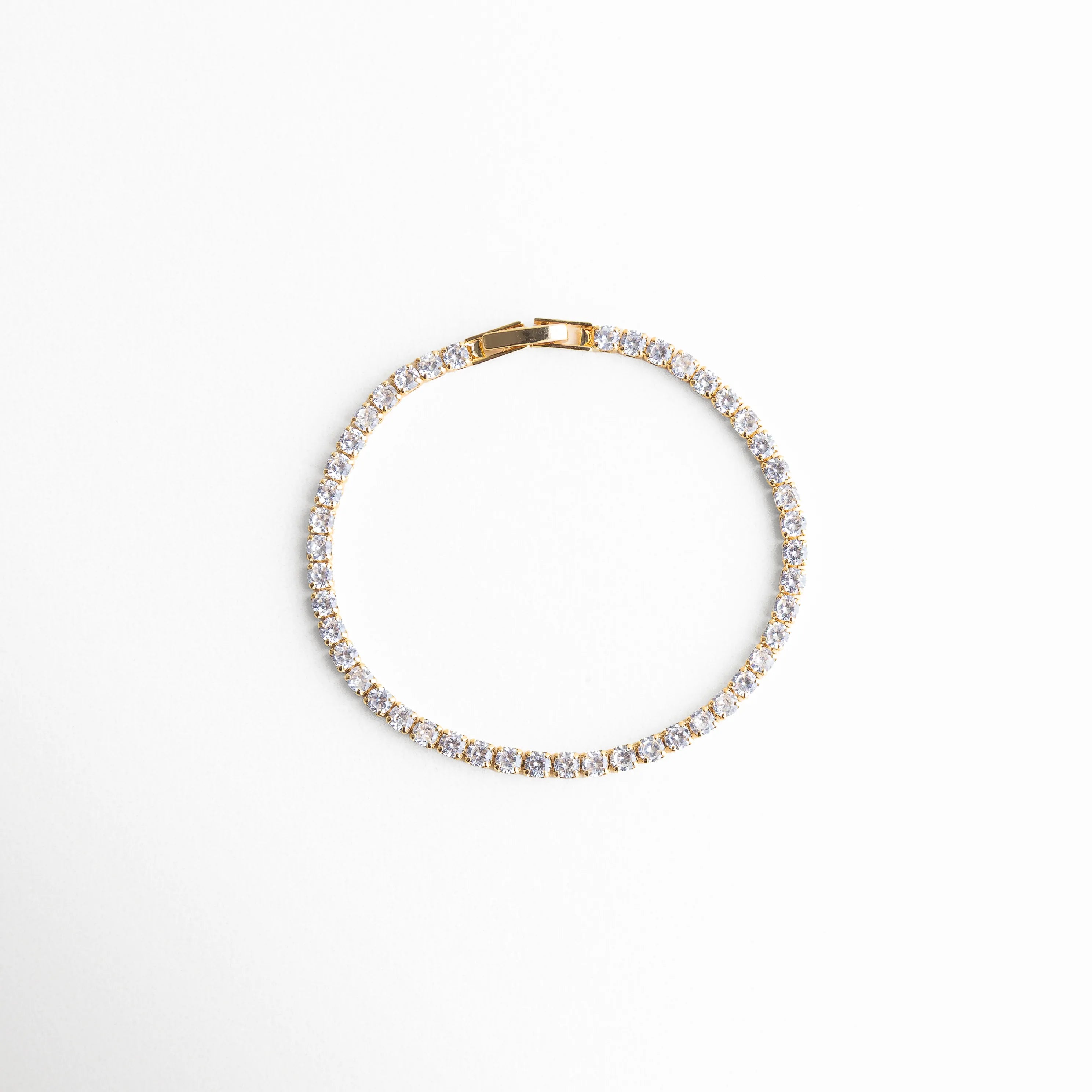 pulsera tennis vista superior, pulsera elegante plateada, joyería clásica moderna, pulsera femenina atemporal, accesorios plateados chic, pulsera con piedras brillantes, joyería delicada mujer, pulsera refinada