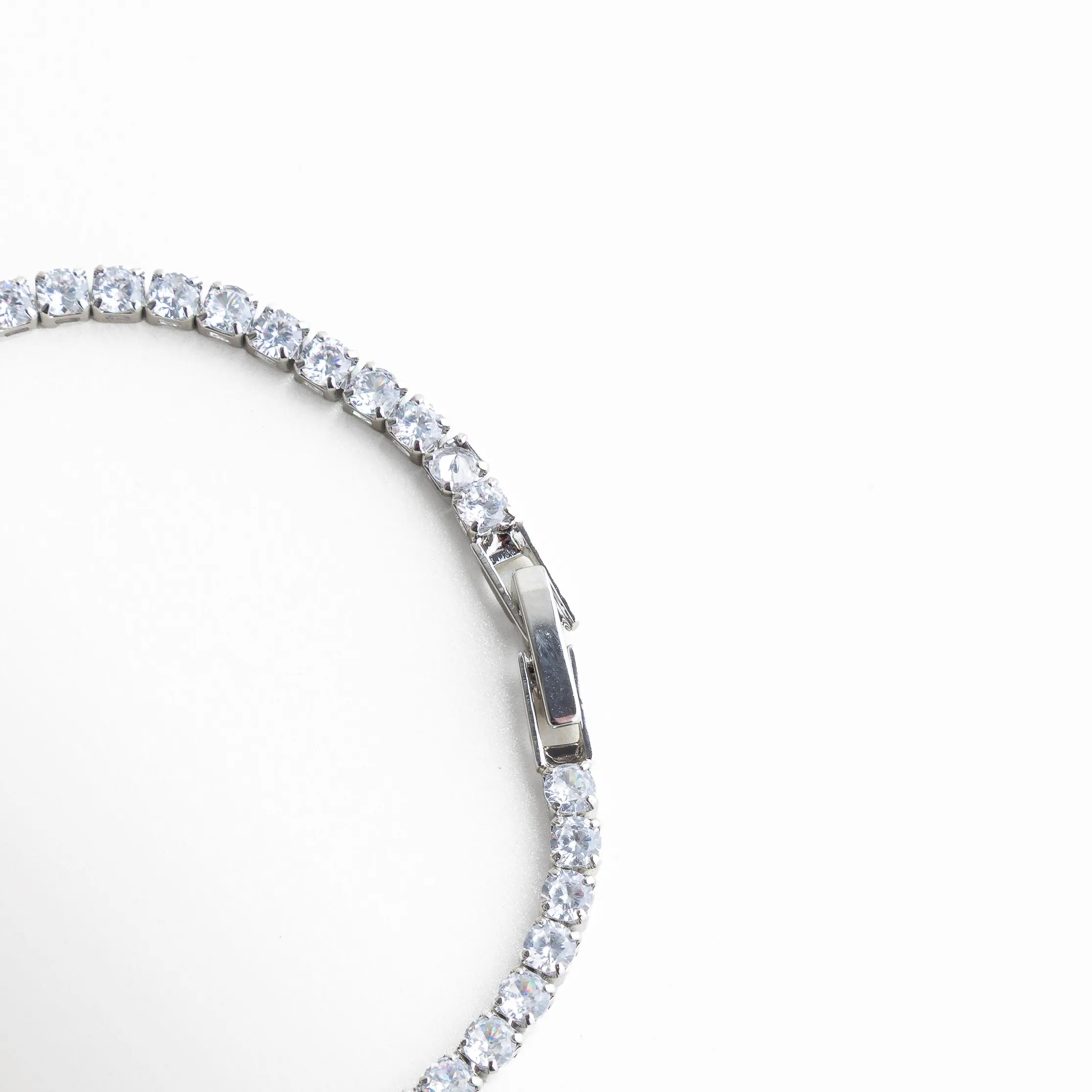 pulsera tennis broche, detalle cierre pulsera, joyería plateada fina, pulsera elegante con cierre, accesorios sofisticados mujer, pulsera clásica chic, joyería femenina luminosa, pulsera de diseño elegante