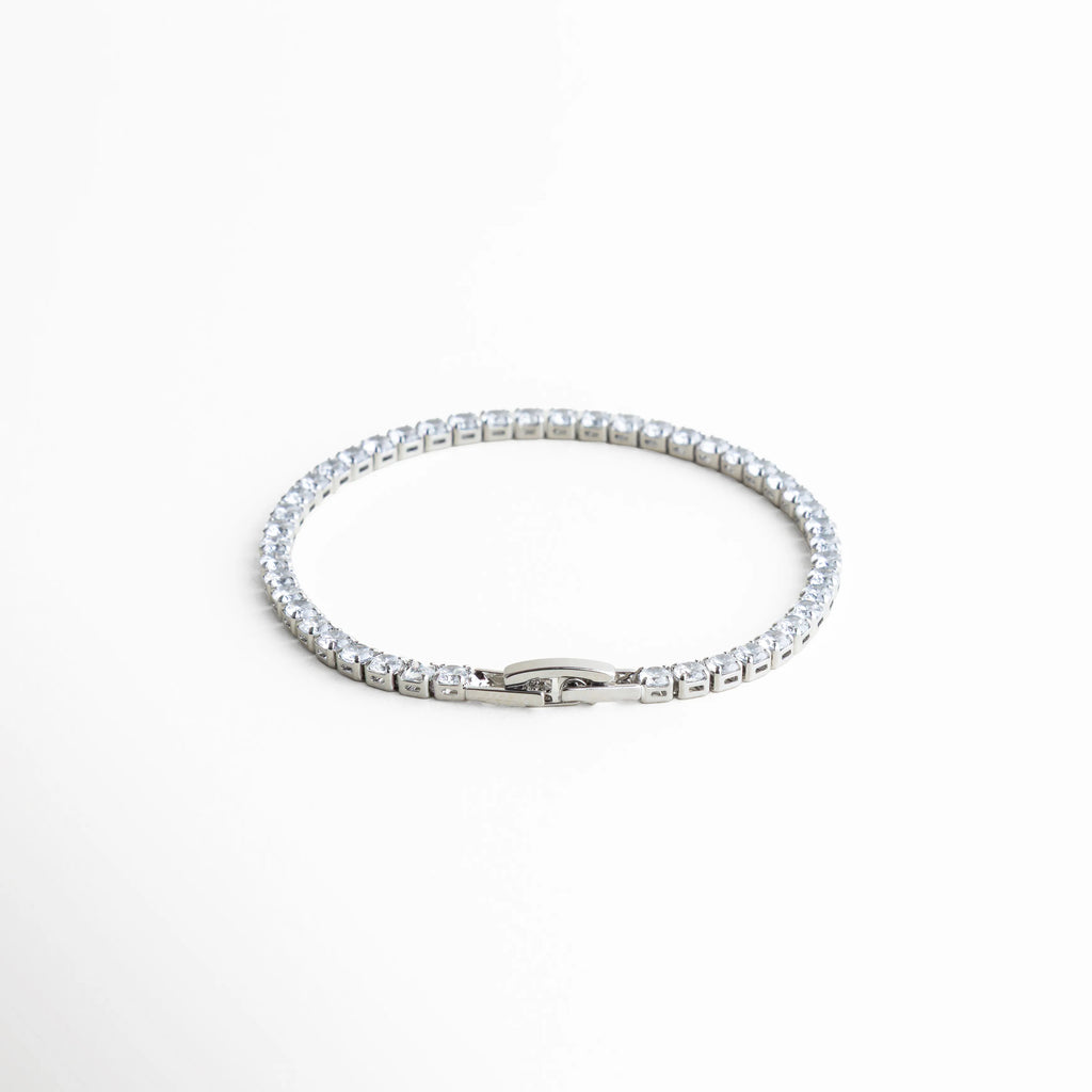pulsera tennis vista superior, pulsera elegante plateada, joyería clásica moderna, pulsera femenina atemporal, accesorios plateados chic, pulsera con piedras brillantes, joyería delicada mujer, pulsera refinada