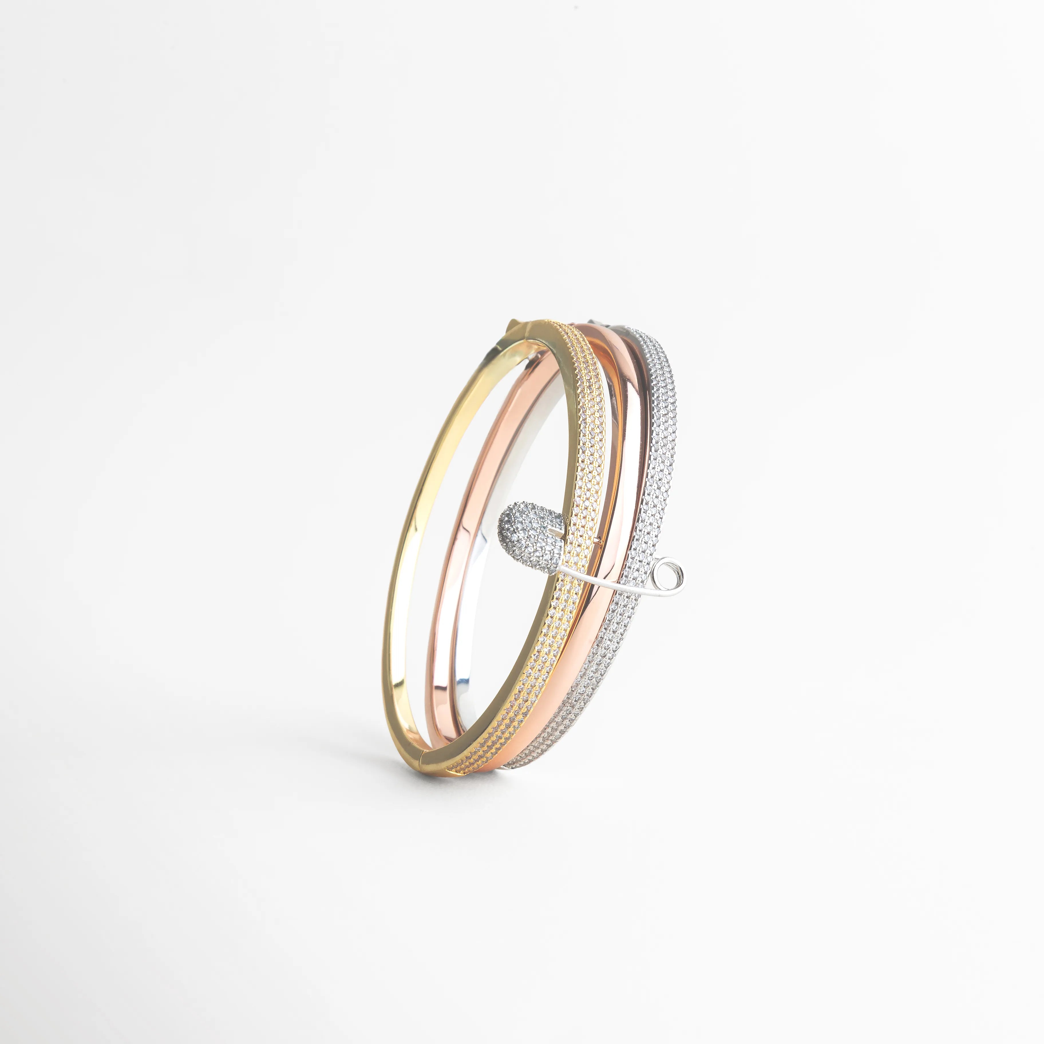 Vista lateral pulsera tritono con zirconias diseño fino y estructurado, Pulsera elegante perfil con acabado en oro rosa blanco y dorado, Detalle lateral pulsera moderna con incrustaciones de zirconias, Pulsera tricolor femenina diseño delgado y sofisticado vista perfil, Vista de lado pulsera con zirconias acabado brillante y elegante