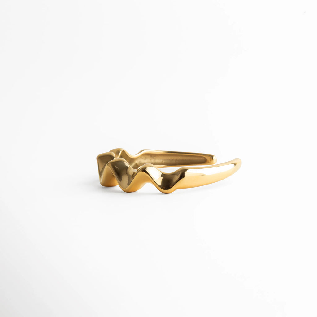 pulsera dorada vista lateral, detalle pulsera ondulada, joyería femenina moderna, pulsera minimal chic, accesorios elegantes mujer, pulsera contemporánea, joyería artística