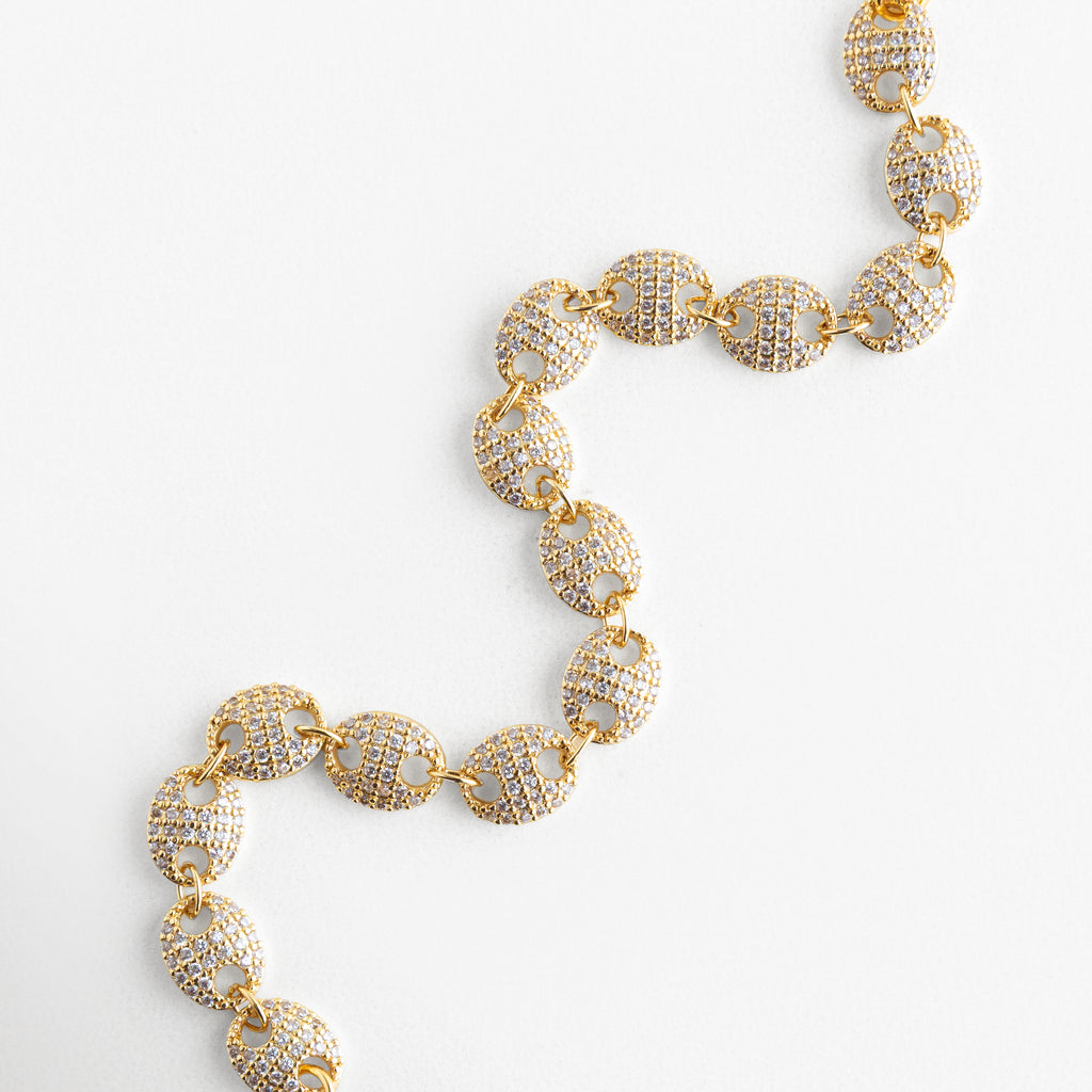 Pulsera de eslabones circulares vista diagonal, Diseño continuo de pulsera con zirconias brillantes, Pulsera dorada elegante vista en diagonal, Pulsera joyería con círculos entrelazados, Pulsera moderna con detalle de zirconias