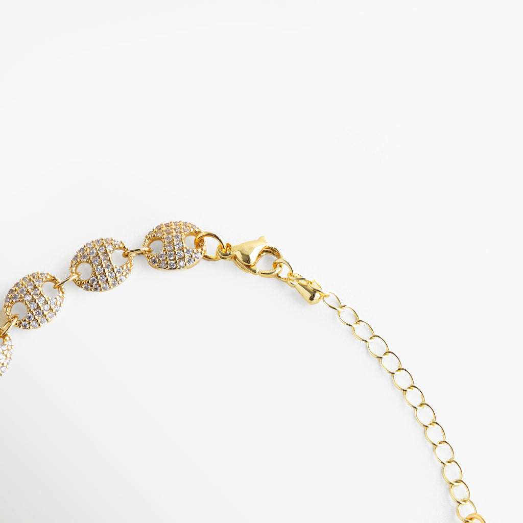 Detalle de zirconias en pulsera dorada, Close up de pulsera con eslabones circulares, Engaste fino de zirconias en pulsera elegante, Textura y brillo de pulsera joyería femenina, Detalle de pulsera sofisticada con acabado pulido
