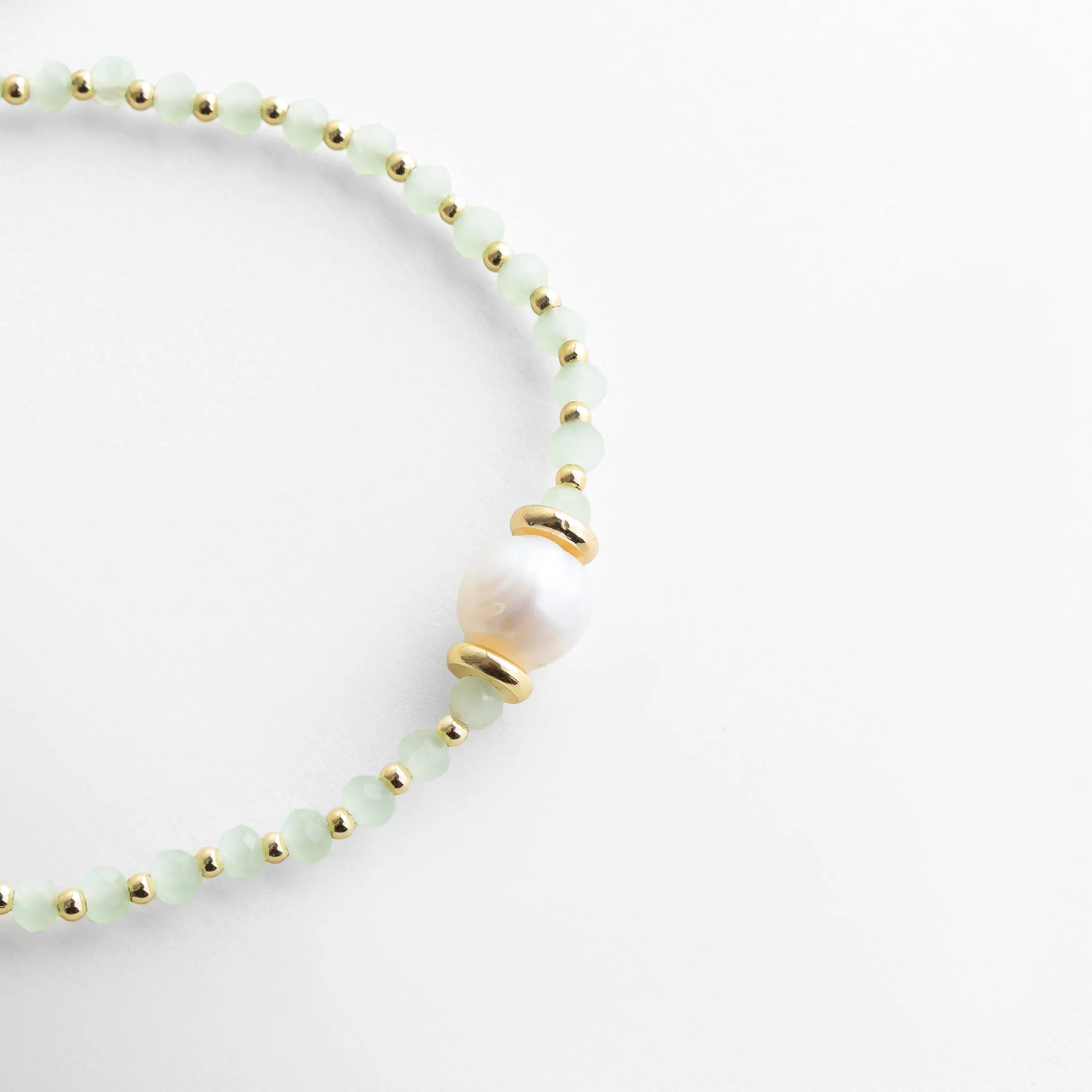 Detalle de pulsera con perla de agua dulce y separadores dorados, Close up de pulsera con perla central y cuentas de cristal delicadas, Pulsera con perla natural y acabado fino, estilo elegante moderno, Detalle de perla de agua dulce en pulsera ajustable con cordón, Pulsera fina con perla central y diseño minimalista sofisticado