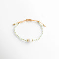 Pulsera ajustable con perlas de agua dulce y cuentas de cristal, diseño delicado, Pulsera fina con cordón de nilón y perla central, estilo elegante y minimalista, Pulsera con perlas naturales y detalles dorados, diseño femenino sofisticado, Pulsera ajustable con cristal y perla de agua dulce, acabado delicado, Pulsera artesanal con perlas y cordón, estilo limpio y elegante
