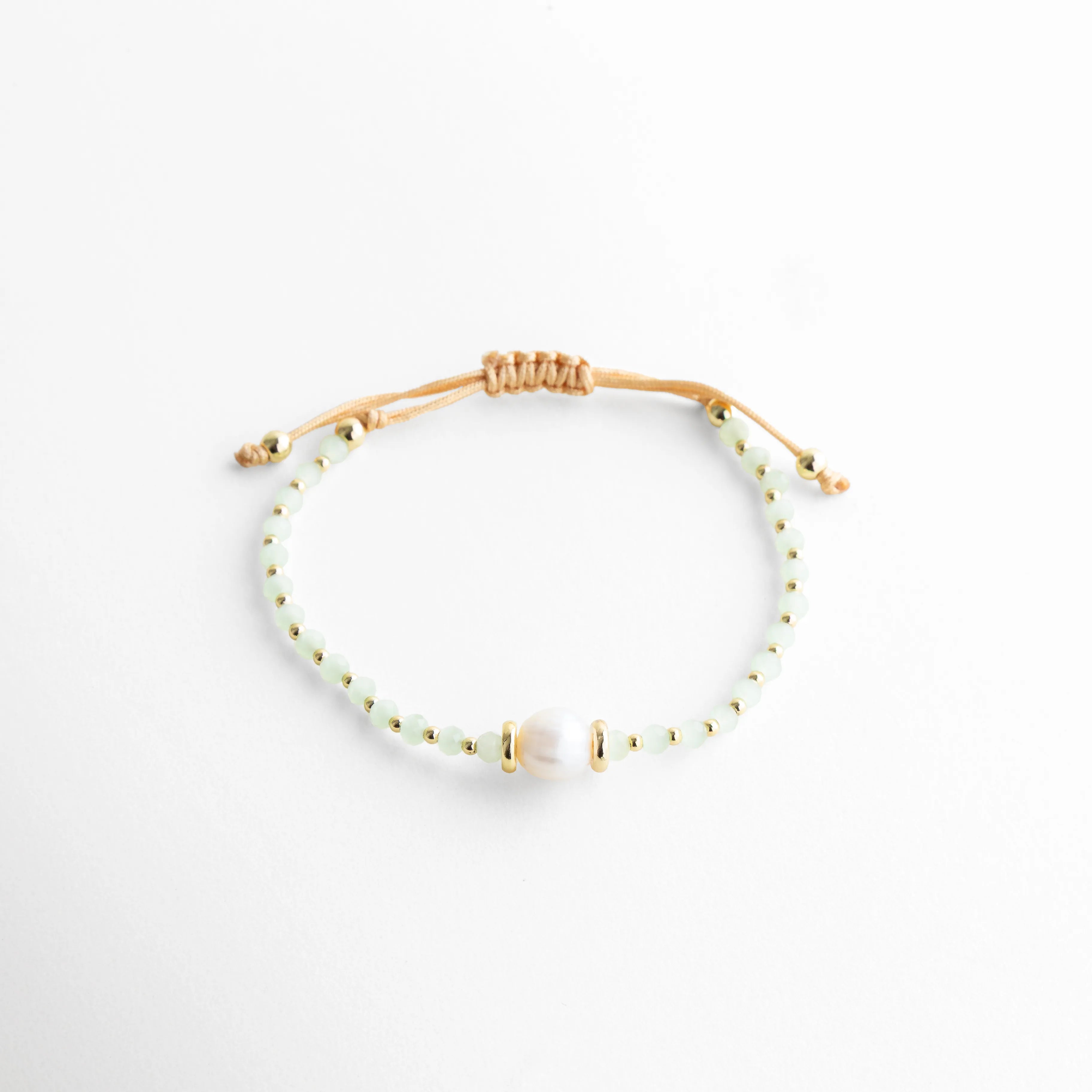 Pulsera ajustable con perlas de agua dulce y cuentas de cristal, diseño delicado, Pulsera fina con cordón de nilón y perla central, estilo elegante y minimalista, Pulsera con perlas naturales y detalles dorados, diseño femenino sofisticado, Pulsera ajustable con cristal y perla de agua dulce, acabado delicado, Pulsera artesanal con perlas y cordón, estilo limpio y elegante