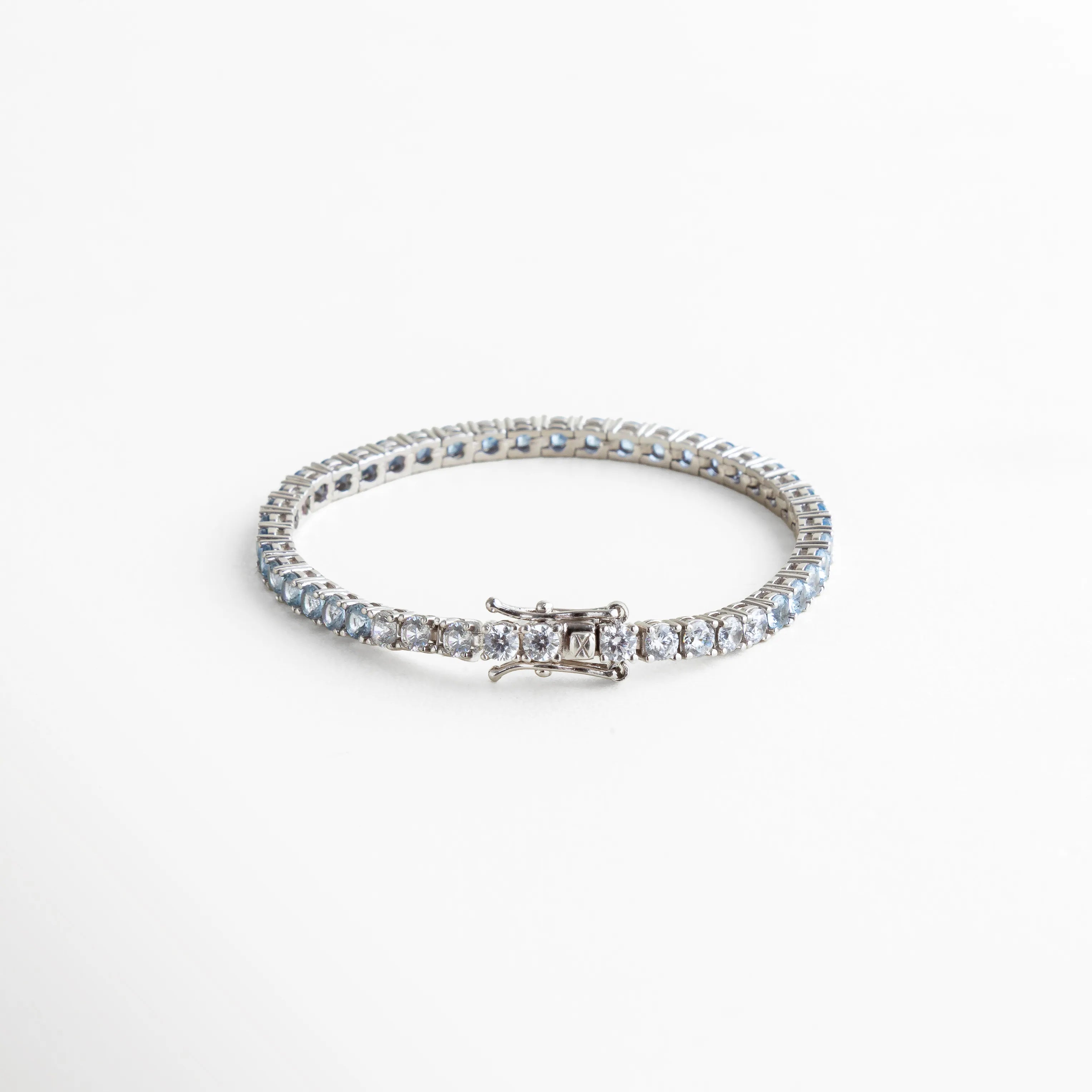 pulsera tennis circular, pulsera azul elegante, joyería plateada con color, pulsera femenina moderna, accesorios azules sofisticados, pulsera chic diaria, joyería brillante mujer, pulsera atemporal