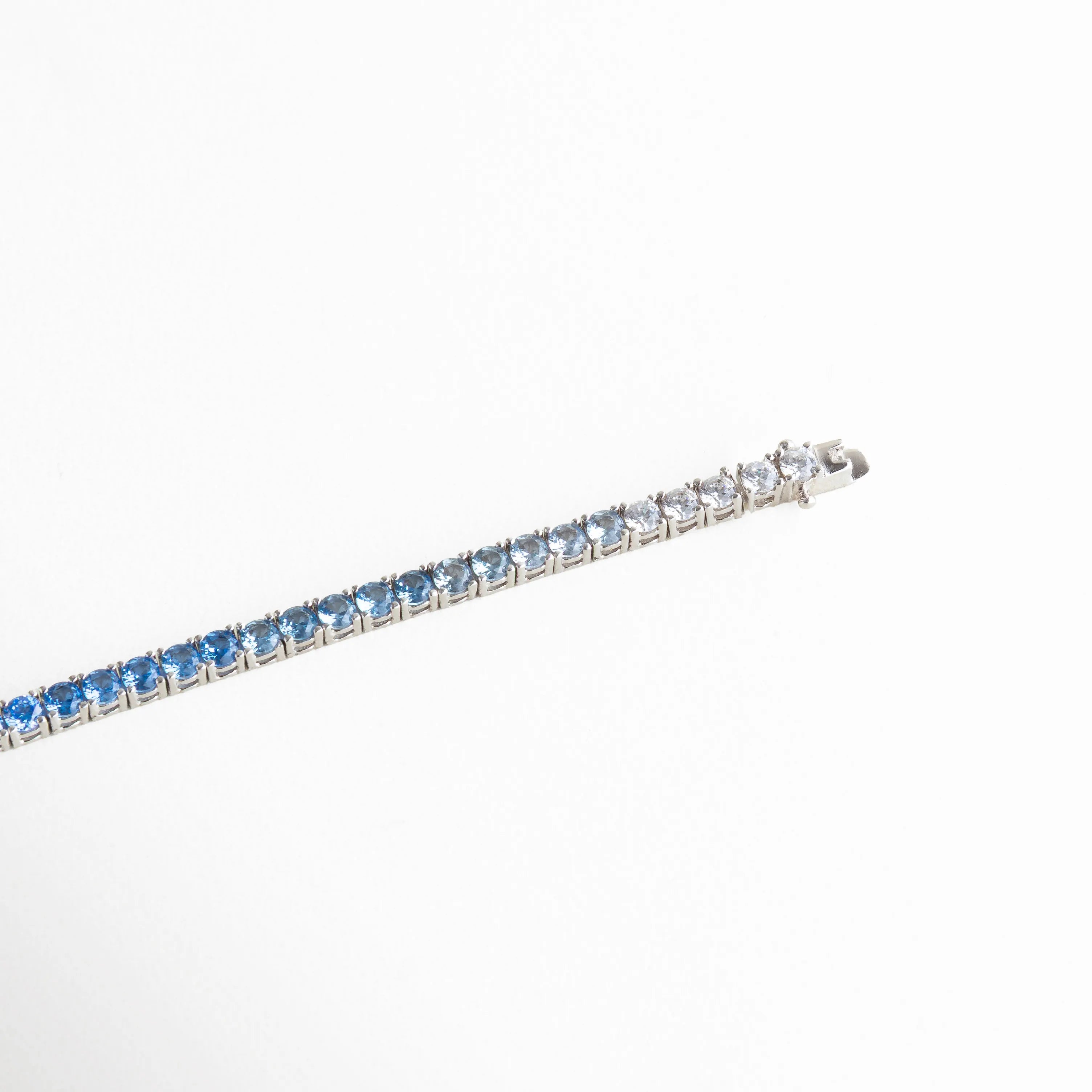 pulsera tennis extendida, pulsera azul larga, joyería brillante moderna, pulsera con piedras alineadas, accesorios femeninos con color, pulsera elegante flexible, joyería minimal colorida, pulsera refinada